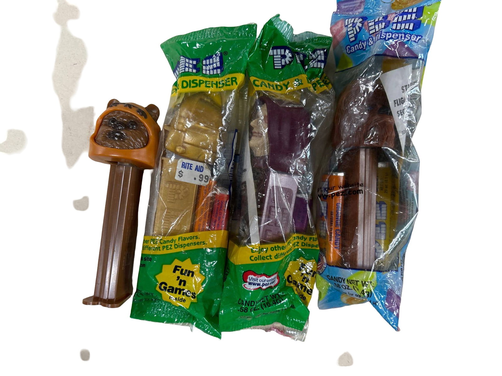 Star Wars-Themed PEZ Dispensers in Original Packaging: Five Star Wars-themed PEZ dispensers, each in original packaging. Designs include recognizable characters such as Chewbacca and Emperor Palpatine, with others visible but unopened. Packaging shows min