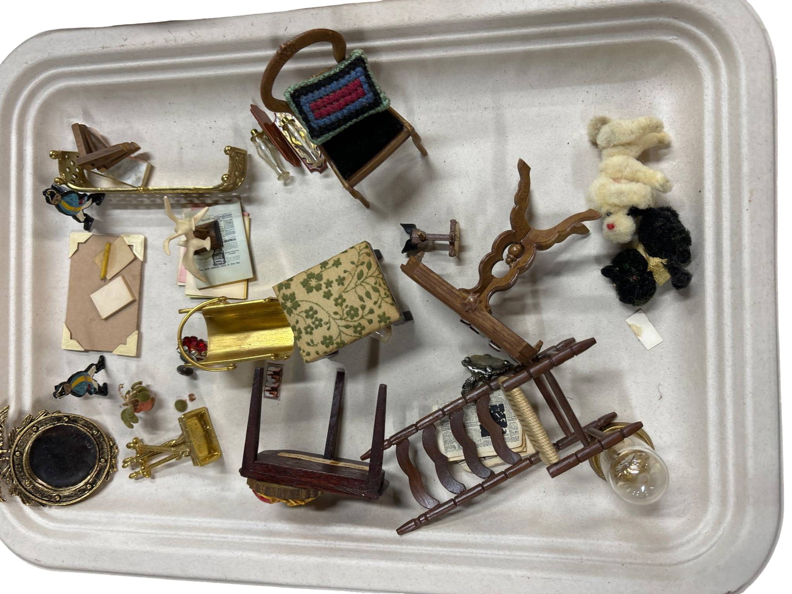 Dollhouse Miniature Furniture and Accessories: Dollhouse miniature items, including furniture and accessories, such as a gilded mirror with eagle motif, a domed mantel clock, a gold-tone cradle, a ladder-back rocking chair, a wooden side table, an