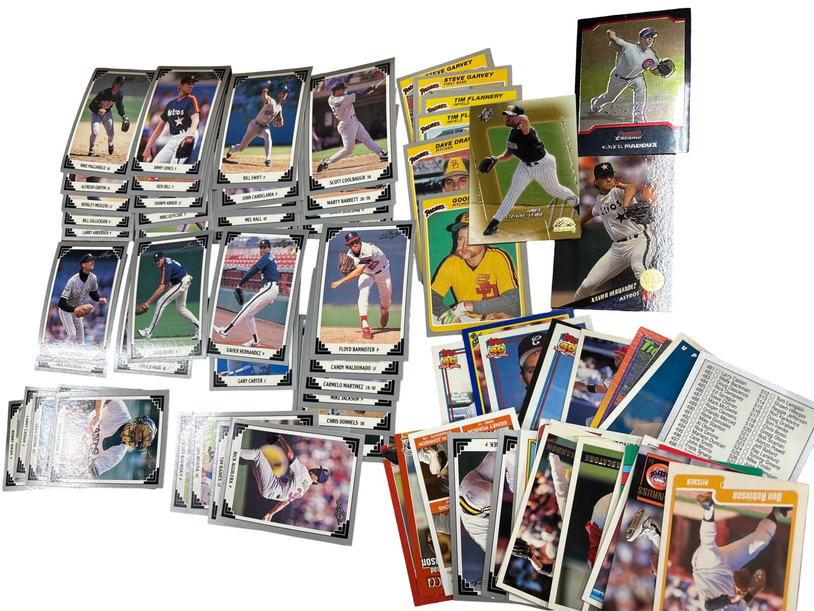 Baseball Trading Cards Featuring Various Players and Brands: A variety of baseball trading cards from different brands and eras. Cards feature various players in action and include brands such as Topps, Donruss, and Bowman, among others. Highlights include card