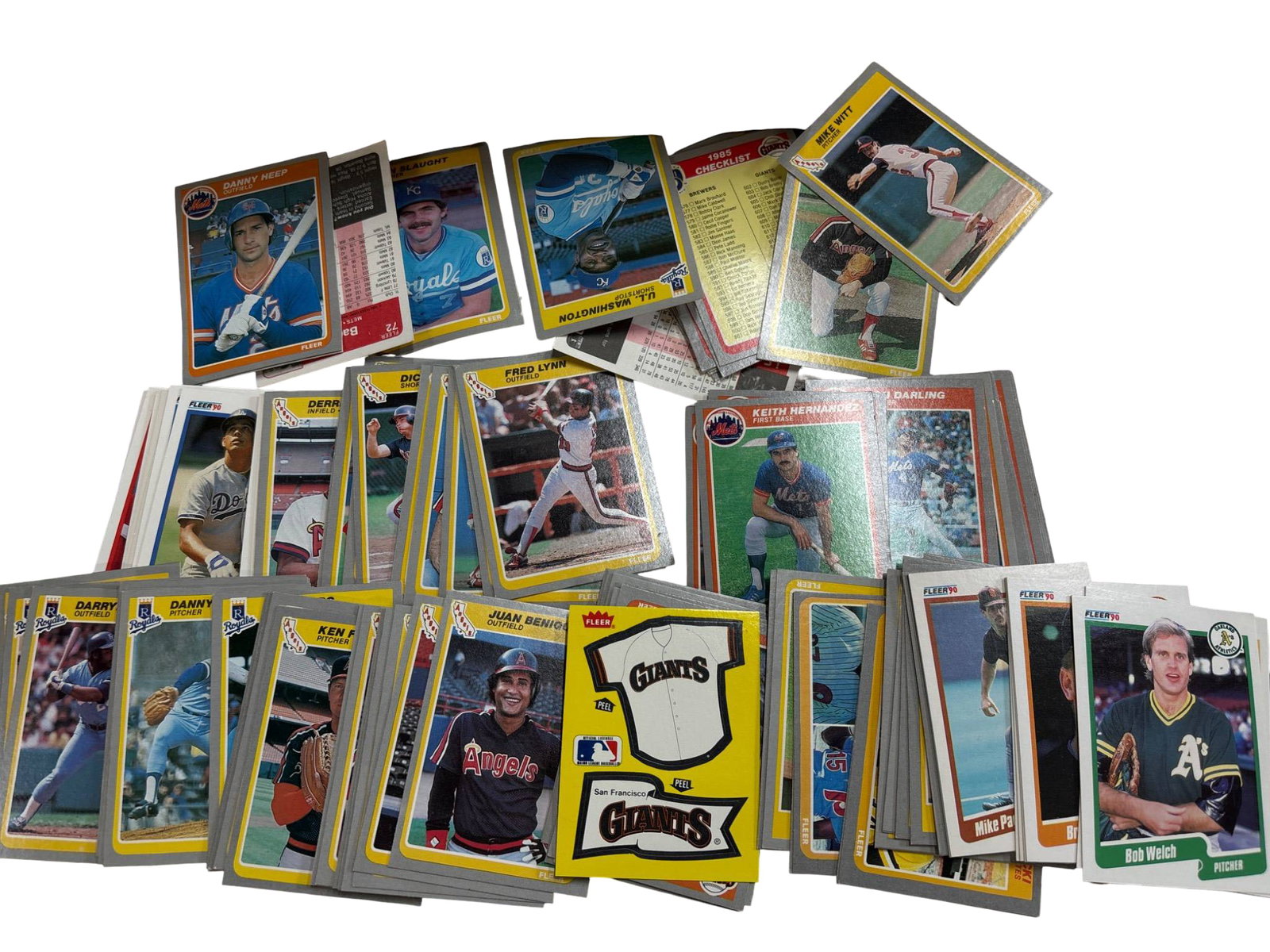 Baseball Trading Cards from Various Teams and Brands: Baseball trading cards featuring players from various teams. Includes cards by prominent manufacturers such as Topps and Donruss. Features vintage designs with players in action and team logos. Cards 