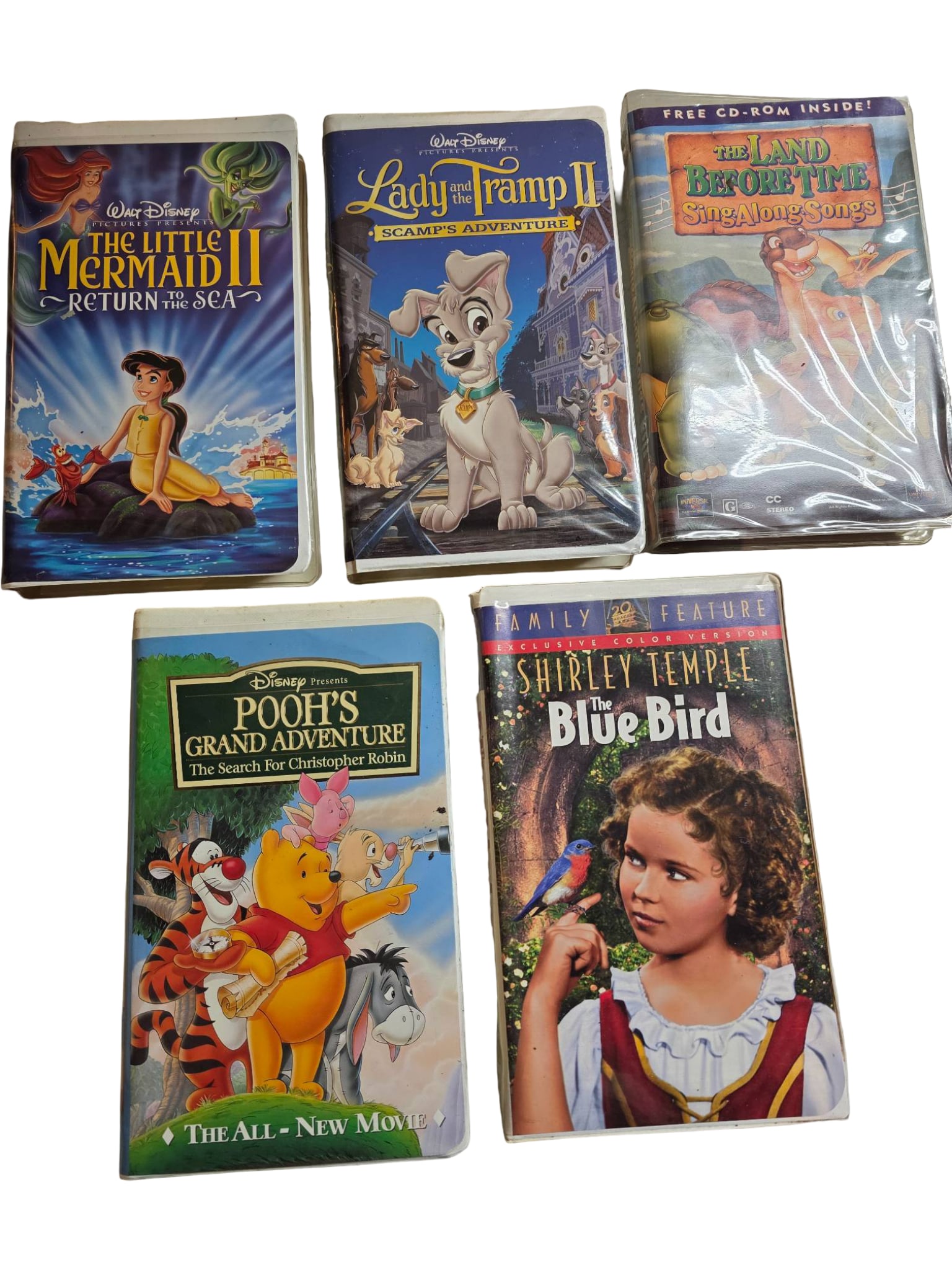 Five VHS Tapes Including Disney and Shirley Temple Titles: Five VHS tapes featuring Disney classics and Shirley Temple’s ‘Blue Bird.’ Includes ‘The Little Mermaid II: Return to the Sea,’ ‘Lady and the Tramp II: Scamp’s Adventure,’ ‘The Land