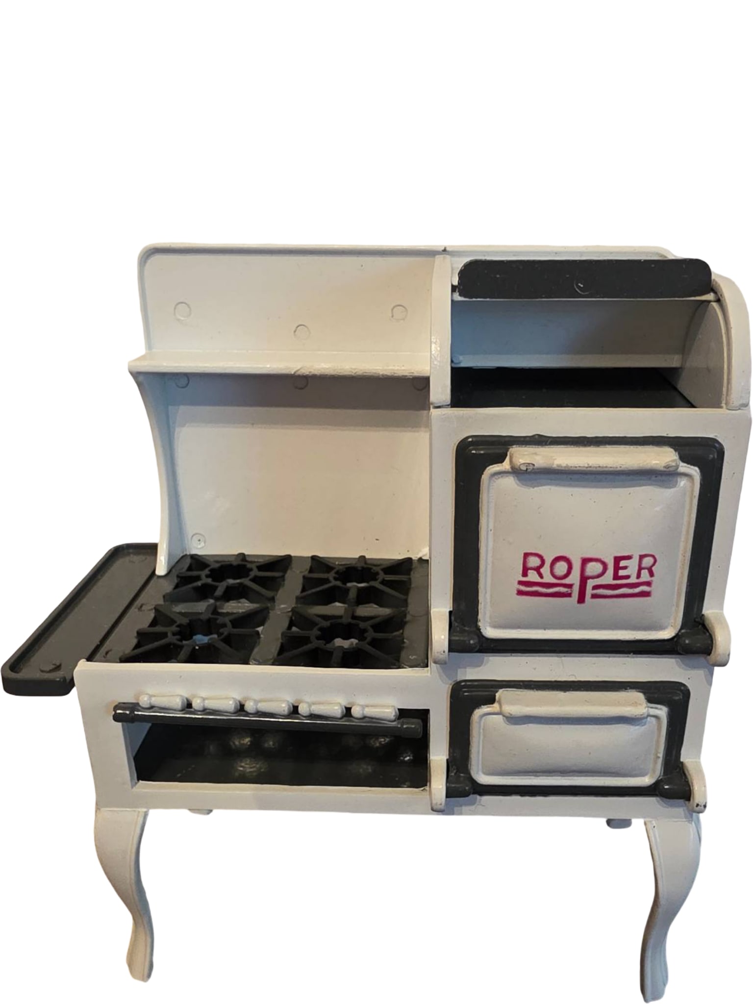 Miniature Roper Metal Stove Replica with Functional Compartments: Miniature Roper stove replica constructed of painted metal in white and black finish. Features simulated burners, an oven door, and warming compartments, with the "Roper" logo prominently displayed. S
