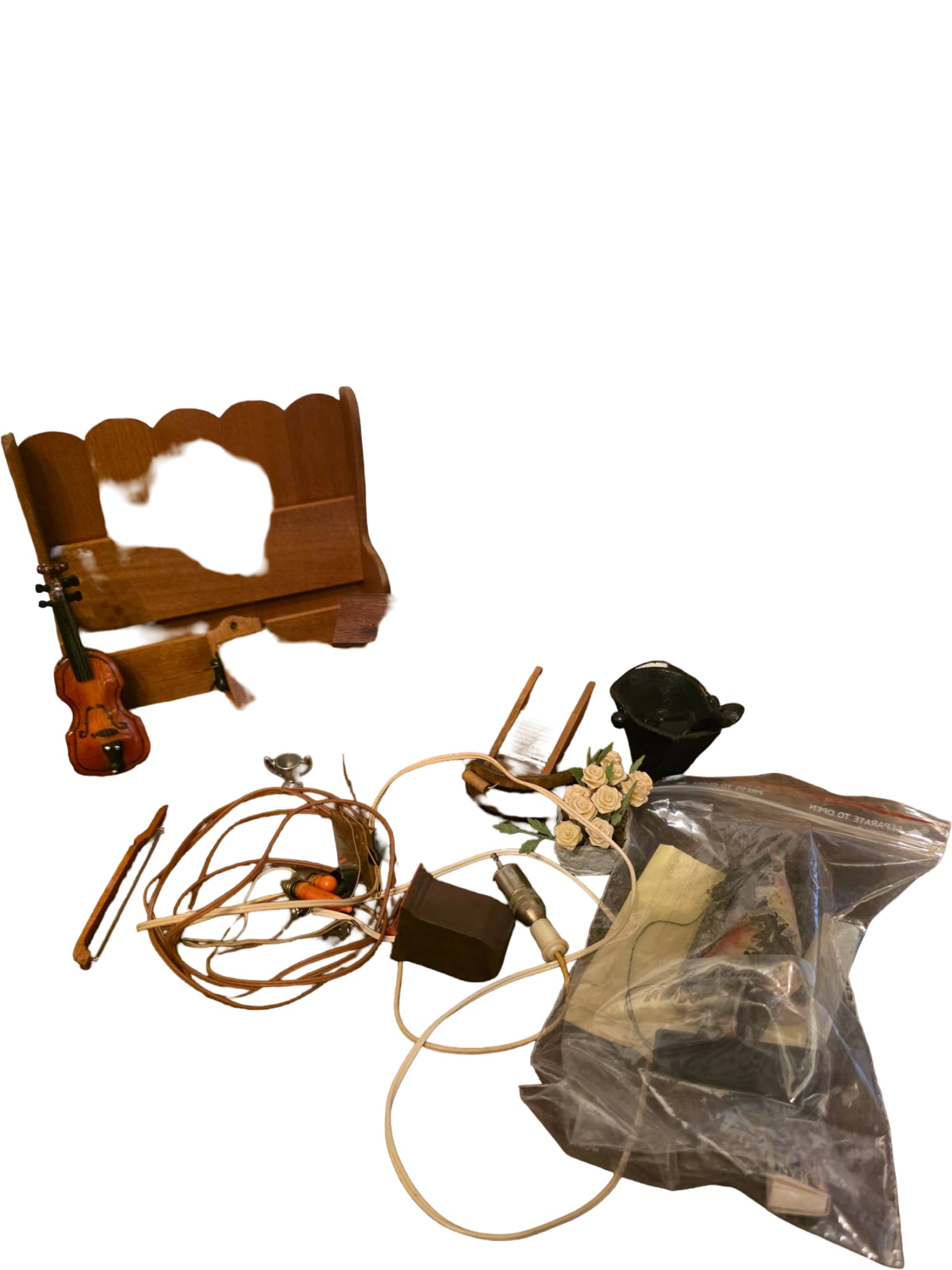 Miniature Dollhouse Furniture and Accessories: Dollhouse-sized items, including a miniature violin with bow, a brick-style fireplace façade, a wooden bench, an outhouse, a small table with book designs, floral arrangement, and additional accessor
