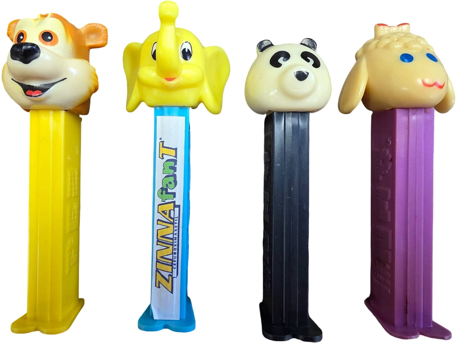 Four Novelty PEZ Dispensers: Animal and Character Designs: Group includes four PEZ dispensers with unique character designs. Features include a lion, a yellow elephant, a panda, and a sheep. Dispensers are made from plastic and showcase colorful, detailed des
