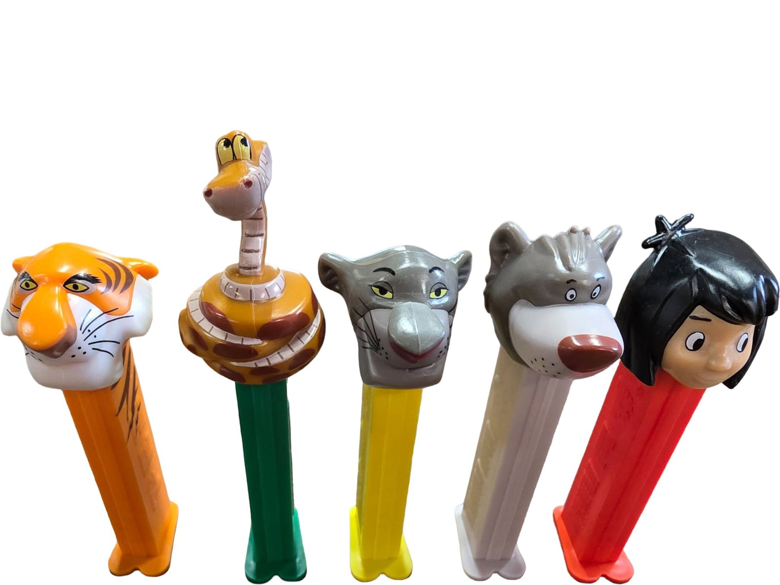 Five Disney Jungle Book PEZ Dispensers: Five PEZ candy dispensers featuring characters from Disney’s ‘The Jungle Book.’ Includes Shere Khan, Kaa, Bagheera, Baloo and Mowgli. Each dispenser has a unique, colorful head design and a matc