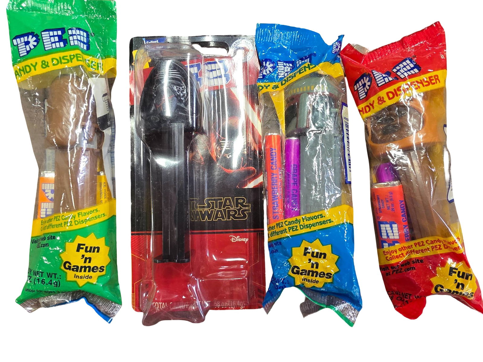 Four Star Wars PEZ Dispensers in Original Packaging: Four PEZ dispensers featuring Star Wars characters, each packaged in unopened original PEZ-branded wrapping. Includes Kylo Ren (in a box), Sith Trooper, Chewbacca and an Ewok in plastic packaging. Pac