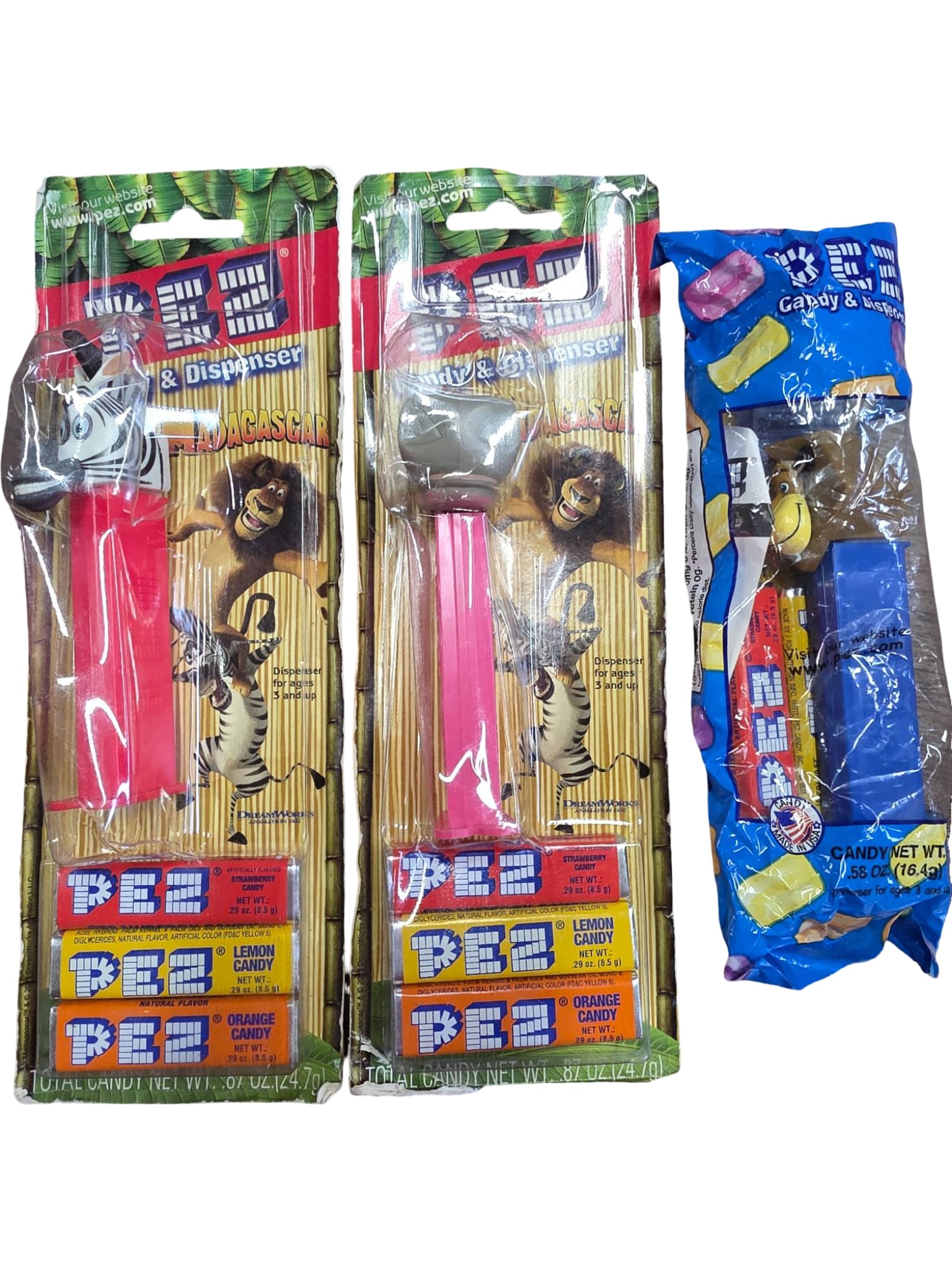 Three PEZ Dispensers Including Madagascar Characters in Original Packaging: Three PEZ candy dispensers in their original packaging. Featuring Madagascar movie characters Alex the Lion, Marty the Zebra and Gloria the Hippopotamus. Packaging shows some wear appropriate for stor