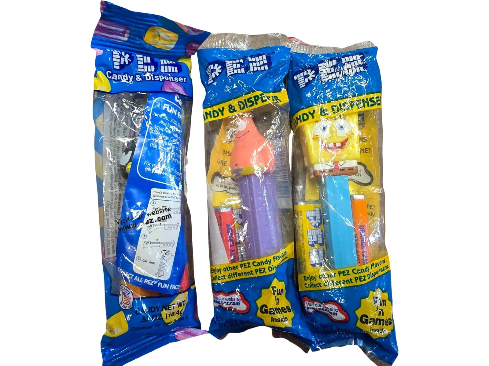 Three PEZ Dispensers Featuring SpongeBob and Sanrio Characters, Sealed: Three factory-sealed PEZ dispensers, including characters from SpongeBob SquarePants and Sanrio. Each dispenser includes candy and retains its original packaging, showing minor storage wear. Packaged 