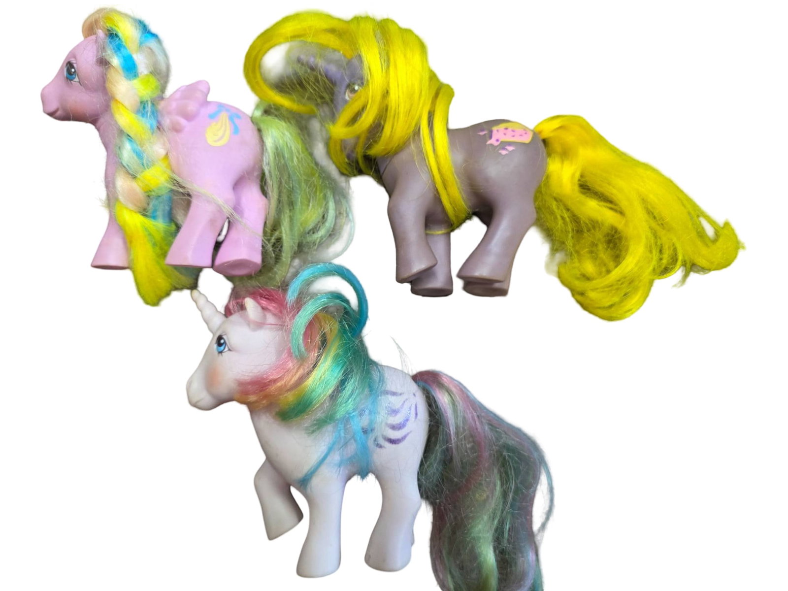 Three Vintage My Little Pony Figures with Multicolored Hair: Three My Little Pony figures, each featuring painted symbols on their bodies and vibrant, multicolored synthetic hair. The lot includes Brysh 'N Grow, Boysenberry Pie and Windy. Minor wear and hair fr