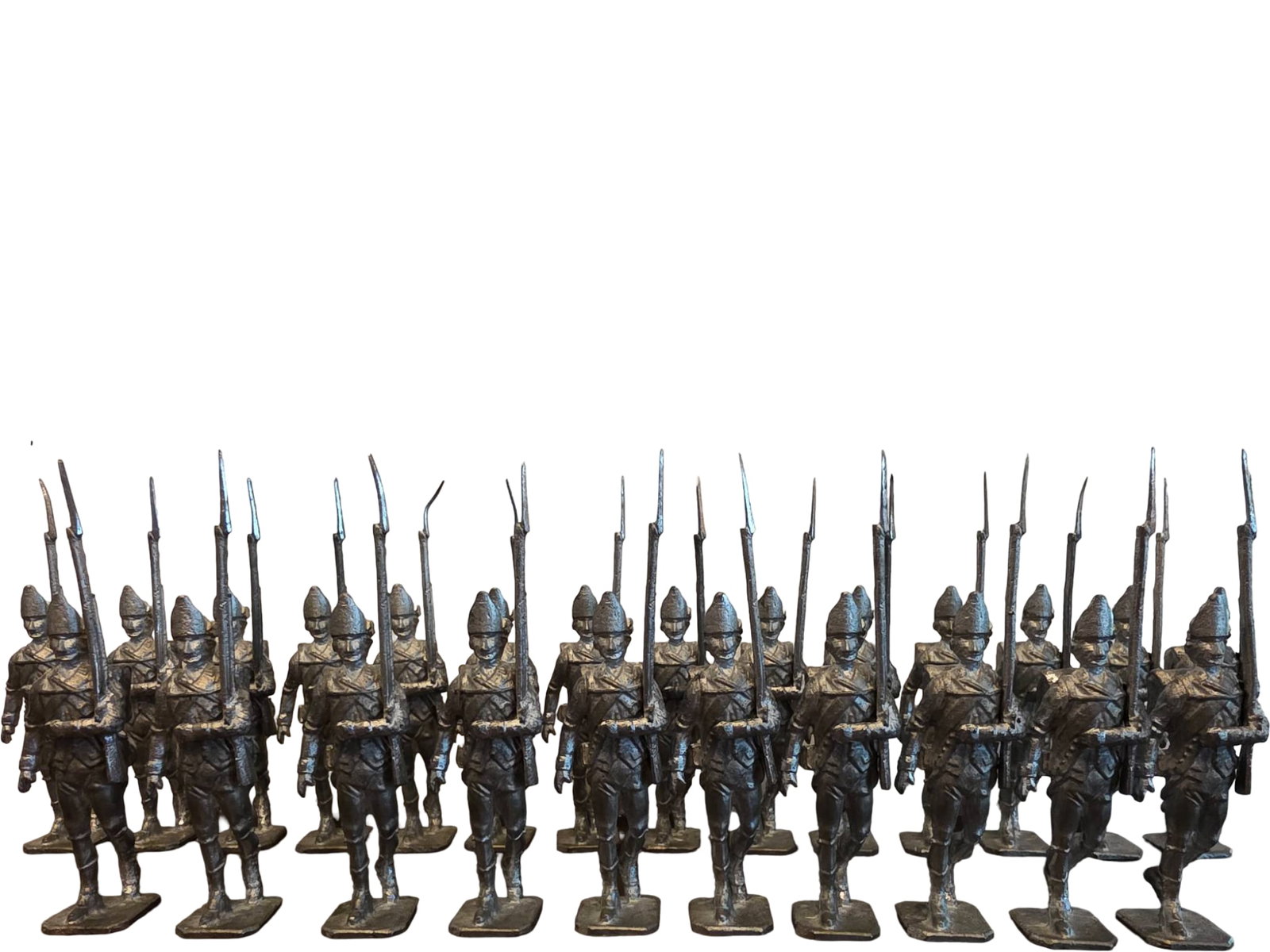 24 Cast Metal Figurines of Soldiers in Military Uniforms: 24 cast metal soldier figurines depicting infantry in detailed military uniforms, standing at attention with rifles and fixed bayonets. The figurines are hand-cast and stand on rectangular bases. Evid