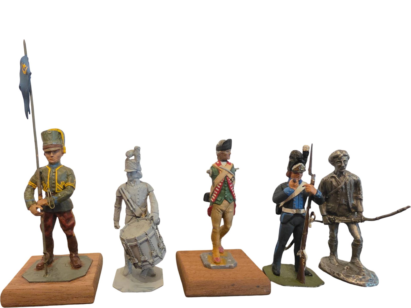 Five Painted Figurines Depicting Historical Soldiers: Five hand-painted figurines representing soldiers from different historical periods. Includes figures holding weapons, flags, and a drum. Made of metal and mounted on individual bases, either wood or