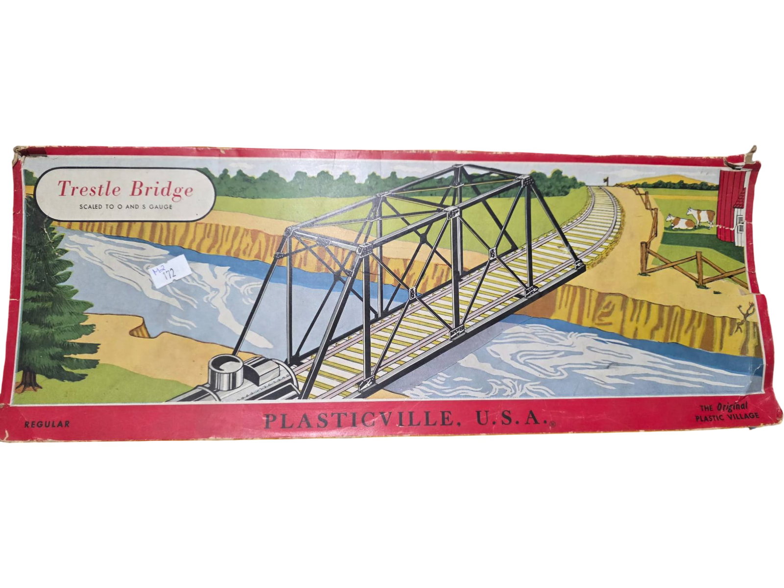 Plasticville USA Trestle Bridge Model Kit in Original Box: Plasticville USA Trestle Bridge model kit, partially assembled, with the original illustrated cardboard box. Box graphics depict the bridge as part of a scenic train layout. The box shows signs of