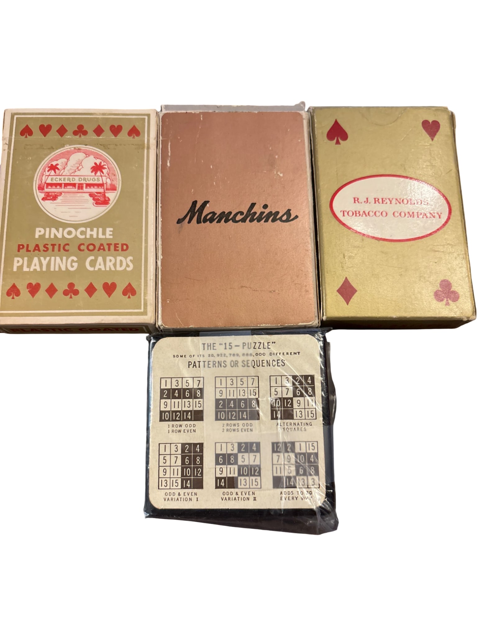 Two Vintage Decks of Playing Cards and ’15-Puzzle’ Game: Includes two decks of vintage playing cards: one marked 'Pinochle Plastic Coated' with an eagle emblem, and one marked 'R.J. Reynolds Tobacco Company,' both with original boxes. Also includes a '15-Pu
