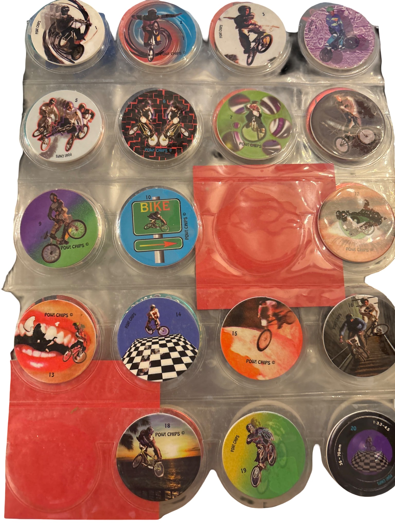 Pog ‘POW! Chips’ Series 1-20 (2 Missing: #11, #17): Complete set of 20 Pog 'POW! Chips,' excluding #11 and #17, totaling 18 pieces. The collection features colorful designs showcasing action scenes, stored in a protective display sheet. Chips appear