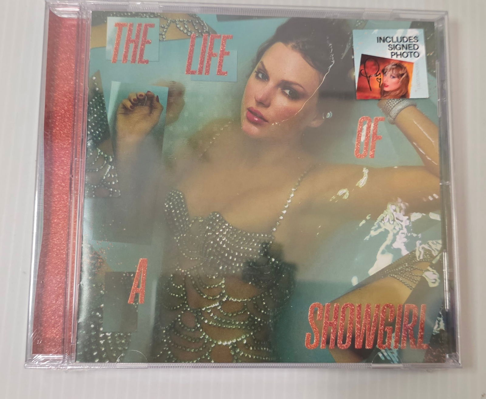 Sealed CD 'The Life of a Showgirl' Includes Signed Photo Insert: CD titled The Life of a Showgirl with an included photo insert that appears signed. The CD case is in shrink wrap, and the wrap shows normal handling wear; signature authenticity is not authenticated.