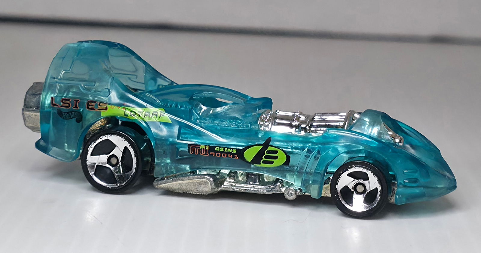1995 Hot Wheels Power Rocket Translucent Aqua Blue Diecast: 1995 Hot Wheels Power Rocket diecast car in translucent aqua blue with visible engine detail and rear rocket thrusters as shown. Used condition with play wear. This preowned item shows wear consistent