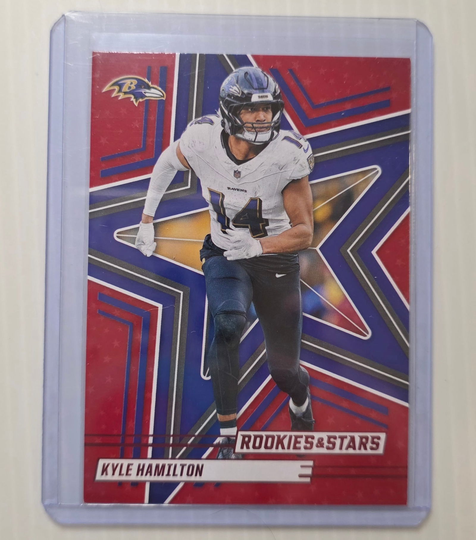 2025 Panini Rookies & Stars Kyle Hamilton #53 Baltimore Ravens NFL Football Card: This is a 2025 Panini Rookies & Stars Kyle Hamilton #53 Baltimore Ravens NFL trading card. It is a standard base card and is not graded. The card is shown in a protective sleeve/top loader and conditi