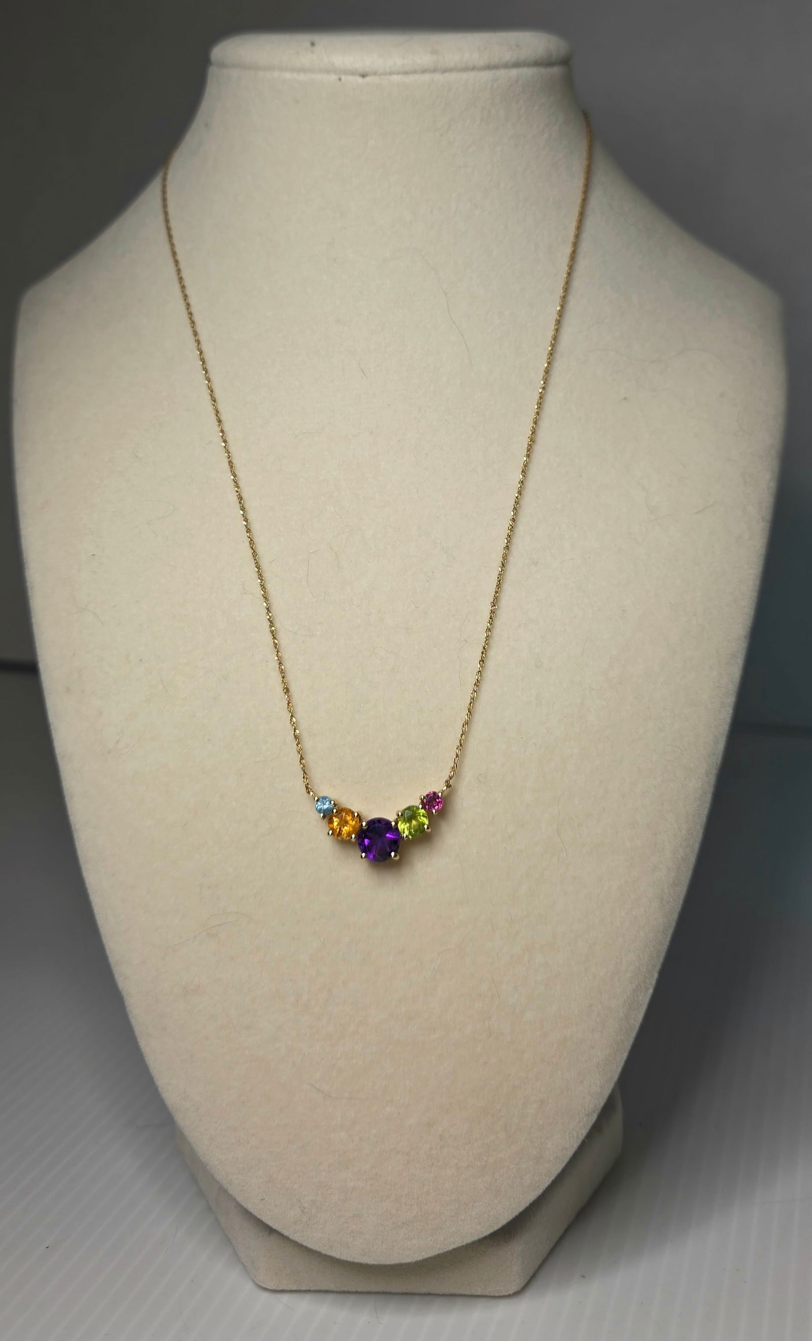 10K Yellow Gold Multi Gemstone Pendant Necklace Macy’s Early 2000s: 10K yellow gold gemstone pendant necklace. Chain and pendant both stamped 10K. Features multiple round cut colored gemstones set in a curved drop design. Originally purchased at Macy’s in the early
