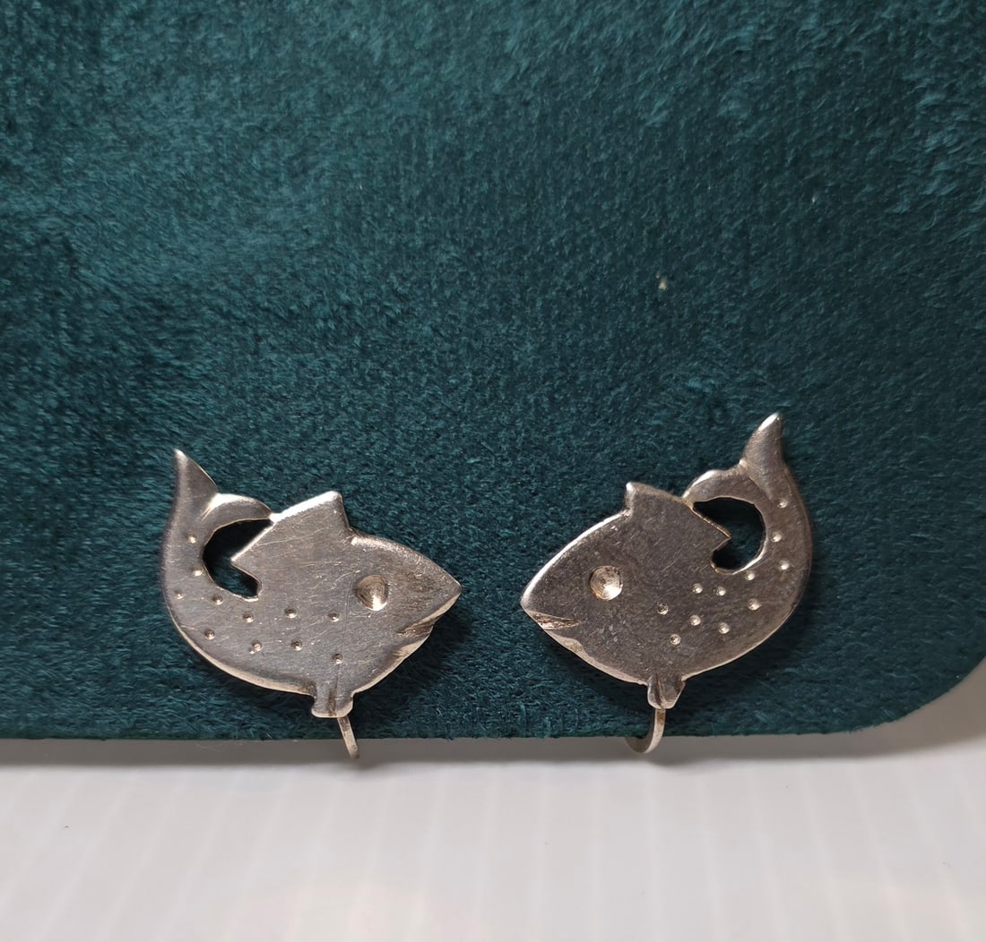 Vintage Sterling Silver Fish Earrings Screw Back Clip On Figural Signed: Vintage sterling silver figural fish earrings. Marked “Sterling” on back of both earrings. Screw back clip on style. Stylized fish design with cutout tail detail and engraved dot accents. Meas