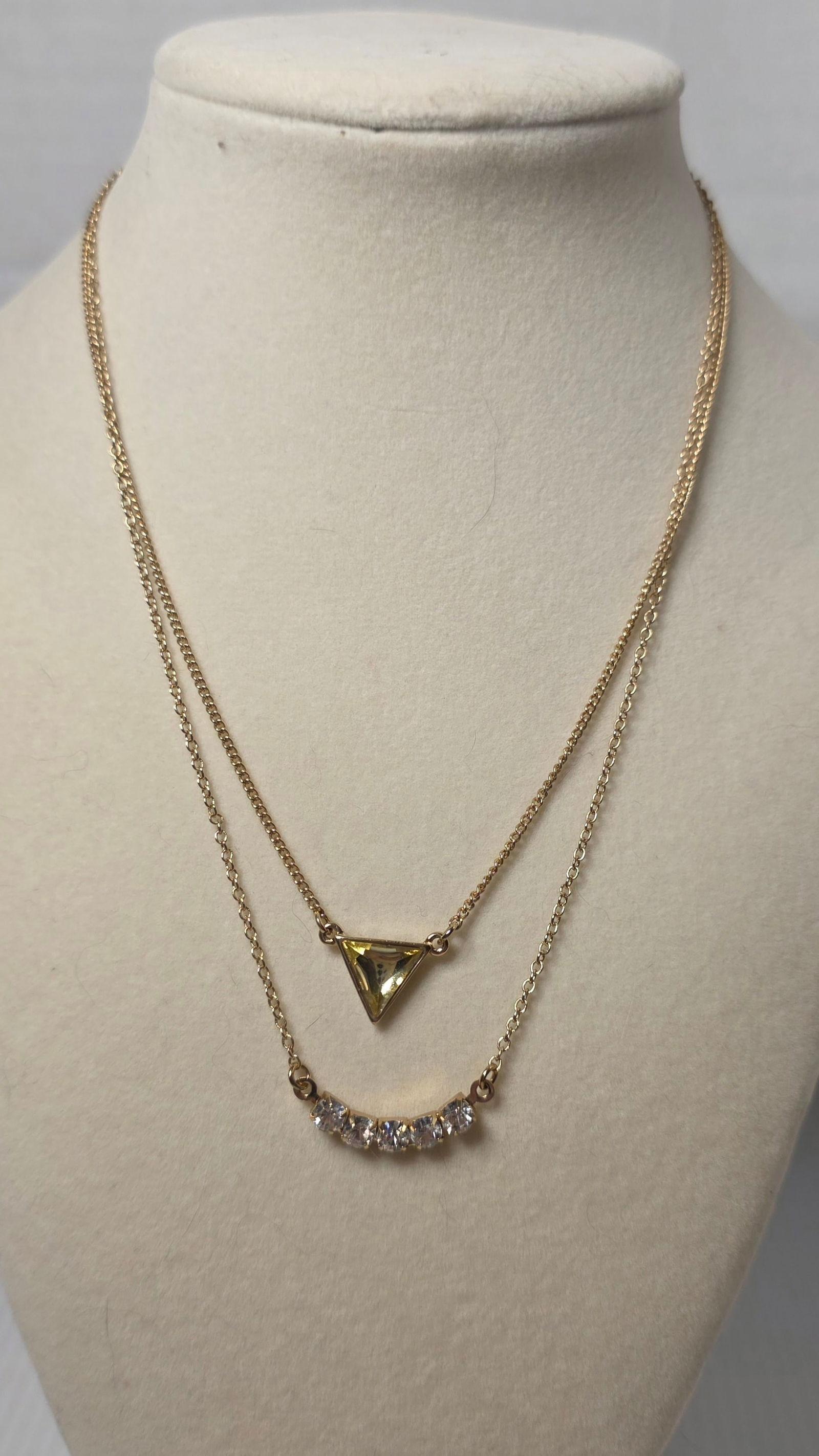 Layered Gold Tone Necklace Set Triangle Yellow Stone Rhinestone Bar Pendant Adjustable: Layered gold tone fashion necklace featuring two strand design. Top strand set with triangular faceted yellow glass style stone in bezel setting. Lower strand features curved clear rhinestone bar acce
