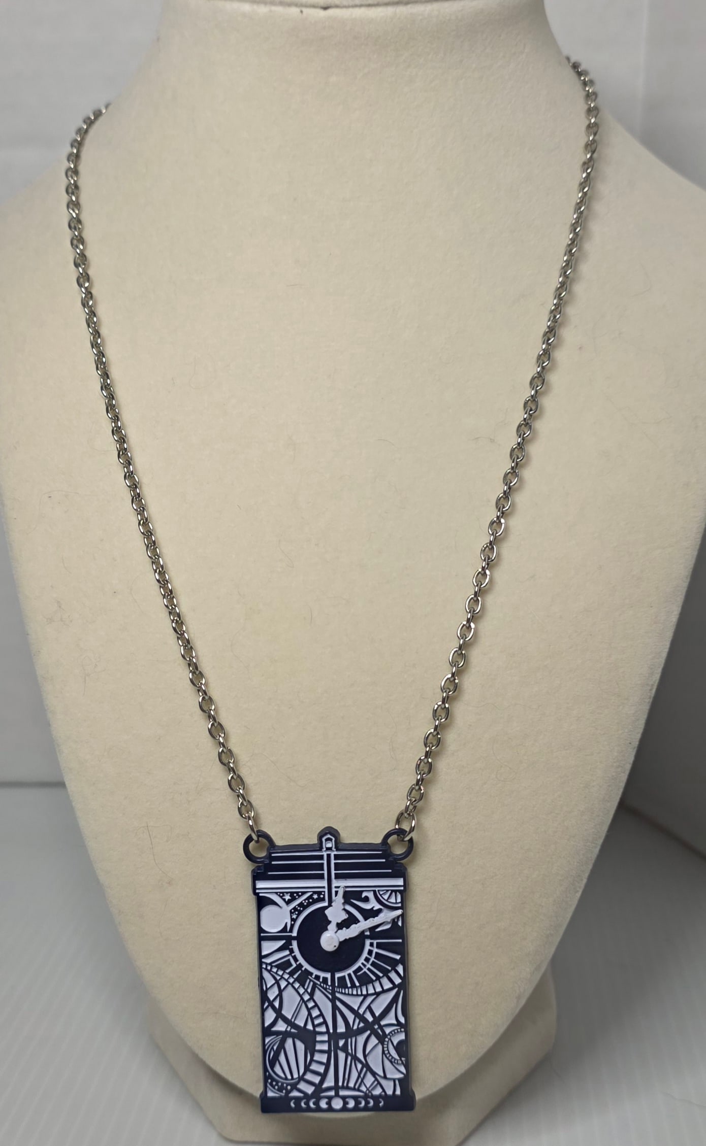 Doctor Who BBC Licensed Enamel Clock Pendant Necklace TARDIS Theme: Doctor Who enamel pendant necklace featuring stylized clock face design with raised hands and detailed graphic background. Back marked © BBC. Silver tone chain with lobster clasp. Measures approximat