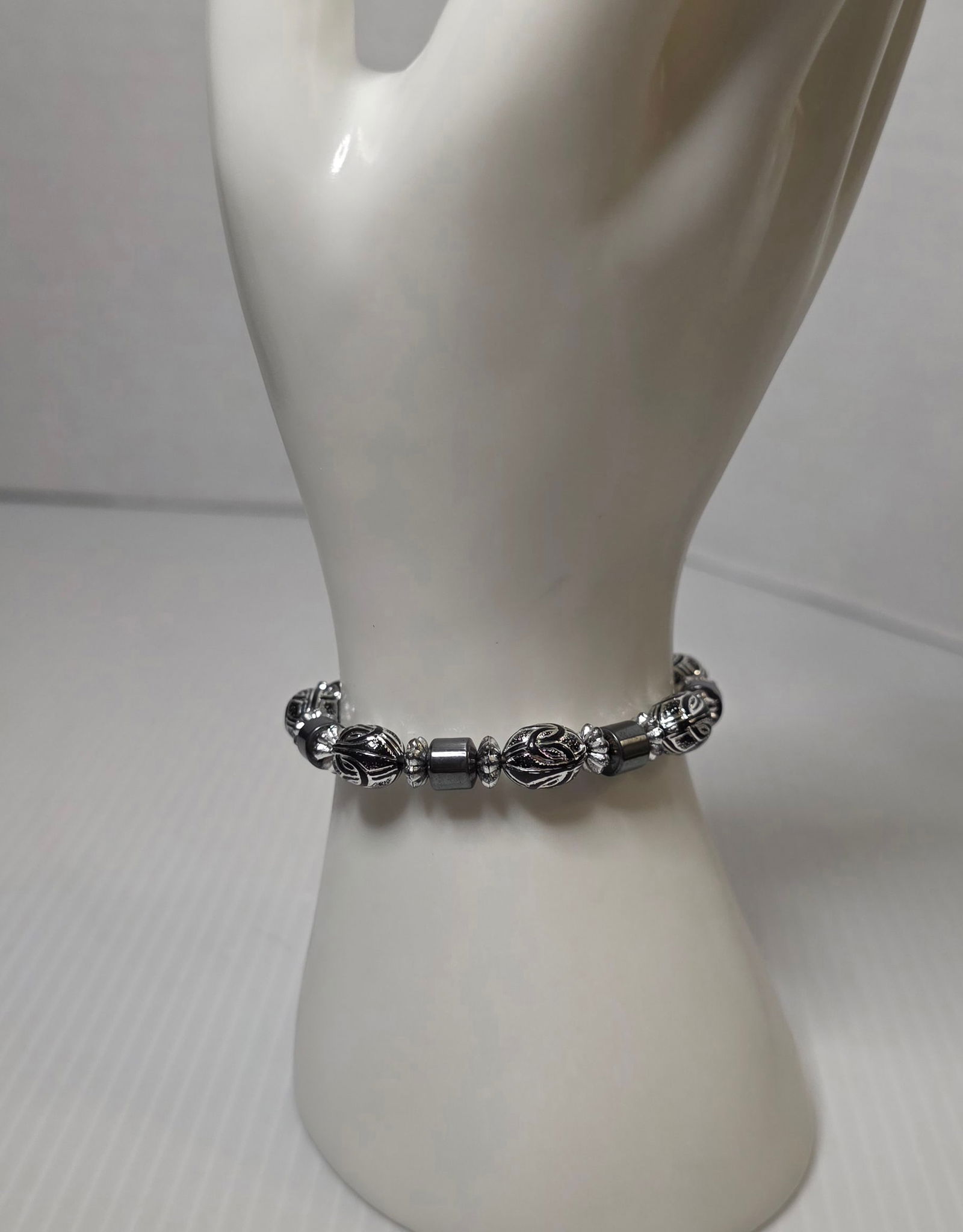 Vintage Hematite Style Bead Bracelet Silver Tone Oval Beads: Vintage bracelet featuring alternating dark gray hematite appearance cylindrical beads and silver tone oval engraved beads with decorative spacer accents. Gold tone lobster clasp closure. Measures app