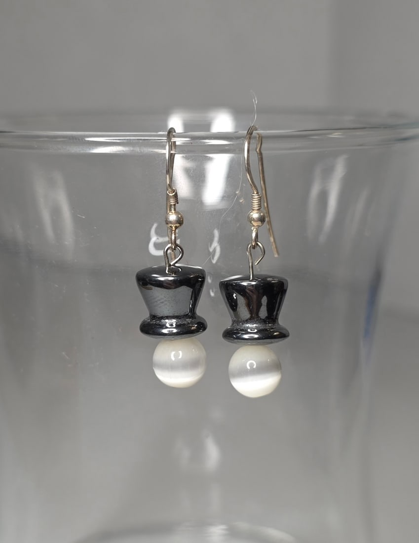 Sterling Silver 925 Dangle Earrings Hematite and White Bead Drop: Dangle earrings featuring dark gray hematite appearance top beads with round white cat’s eye appearance drop beads. Ear wires marked 925 sterling silver. Bead materials untested. Drop length approxi