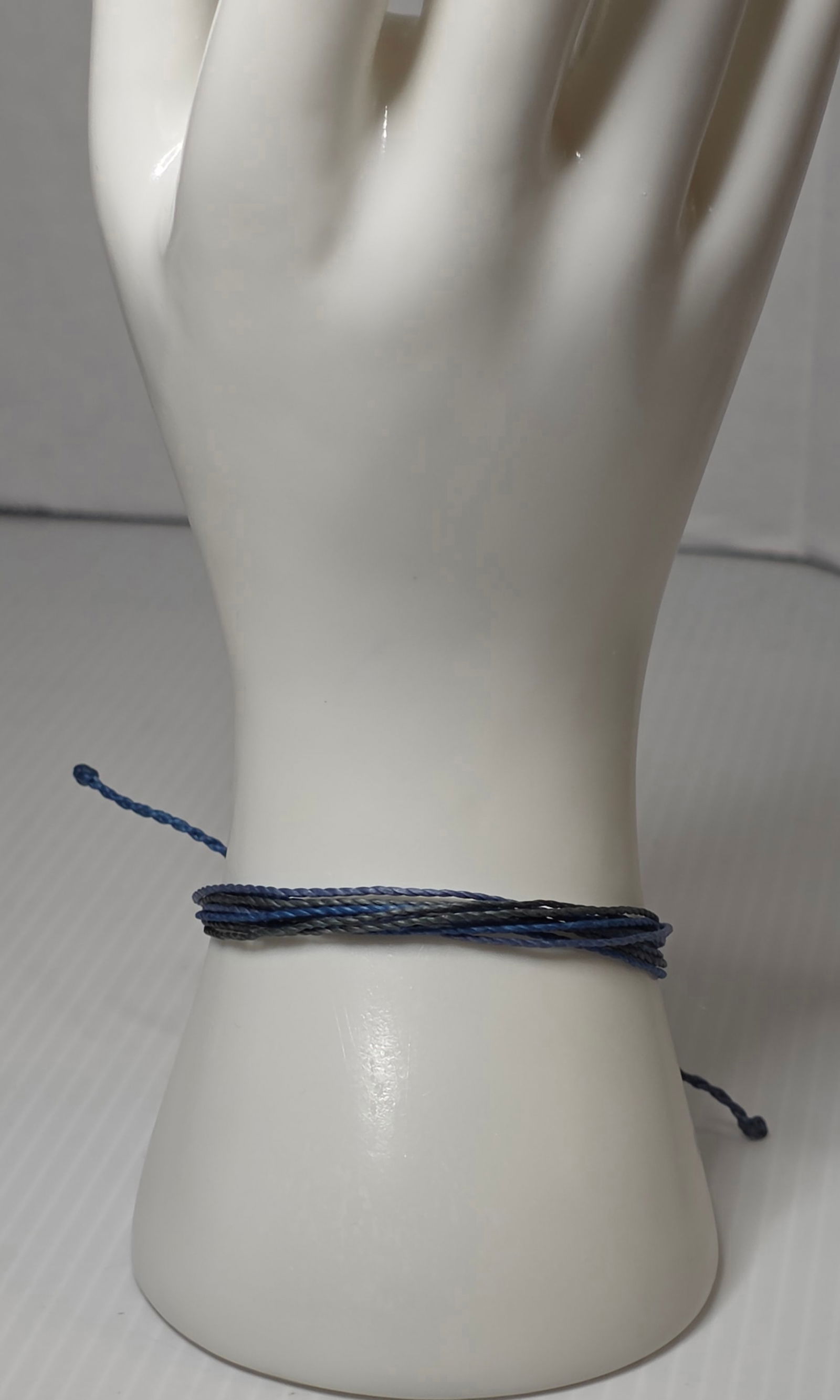 Pura Vida Blue Braided Bracelet Adjustable Cord Beach Surf Style: Authentic Pura Vida braided cord bracelet featuring multi tone blue strands with adjustable sliding knot closure. Silver tone Pura Vida logo charm attached. Casual beach, surf, stackable friendship st