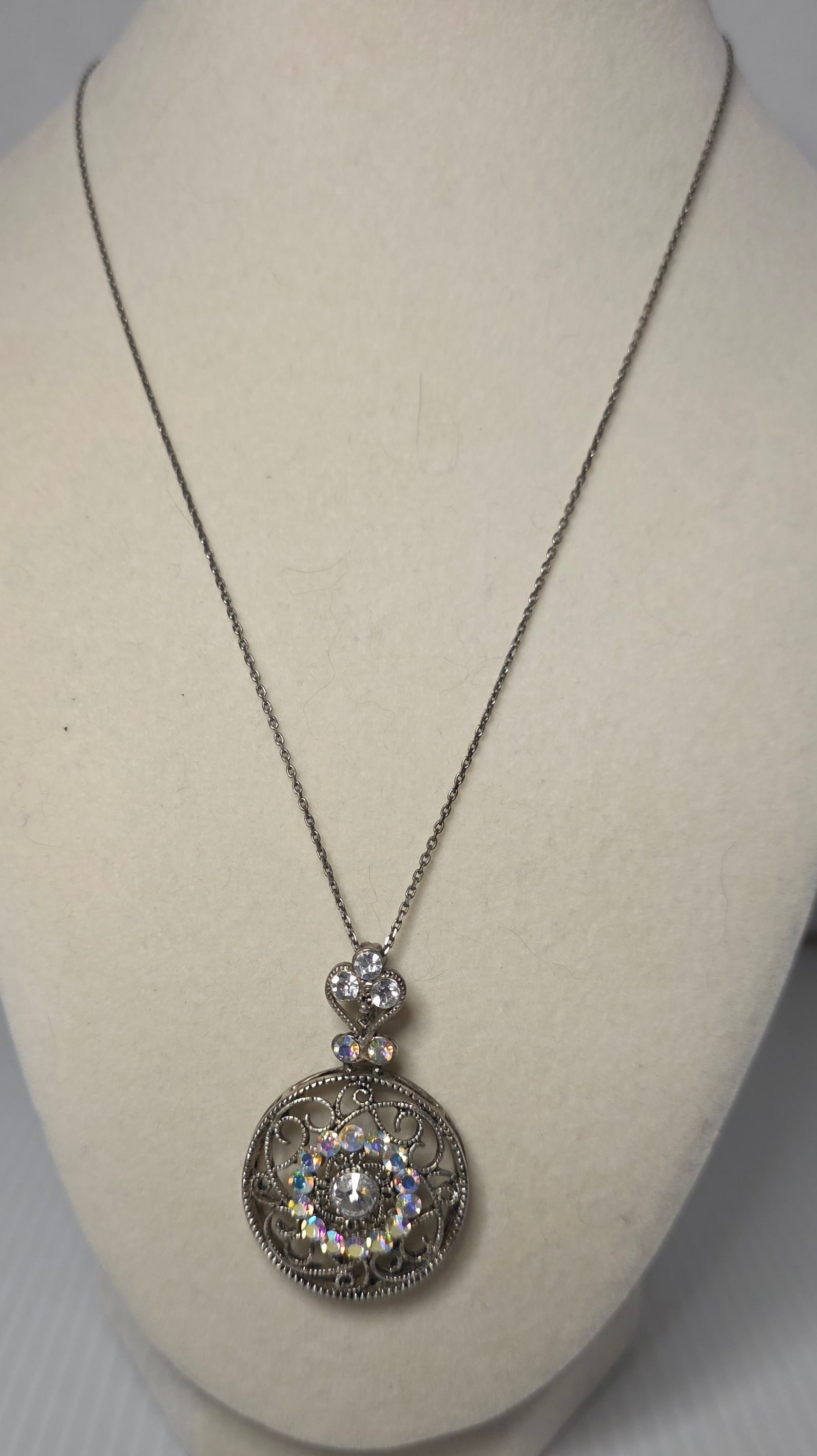 925 Italy Sterling Silver Filigree Pendant Necklace Rhinestone: Sterling silver necklace marked 925 Italy with maker mark. Features ornate round filigree pendant set with clear center stone and iridescent rhinestone halo accents. Additional rhinestones set above i