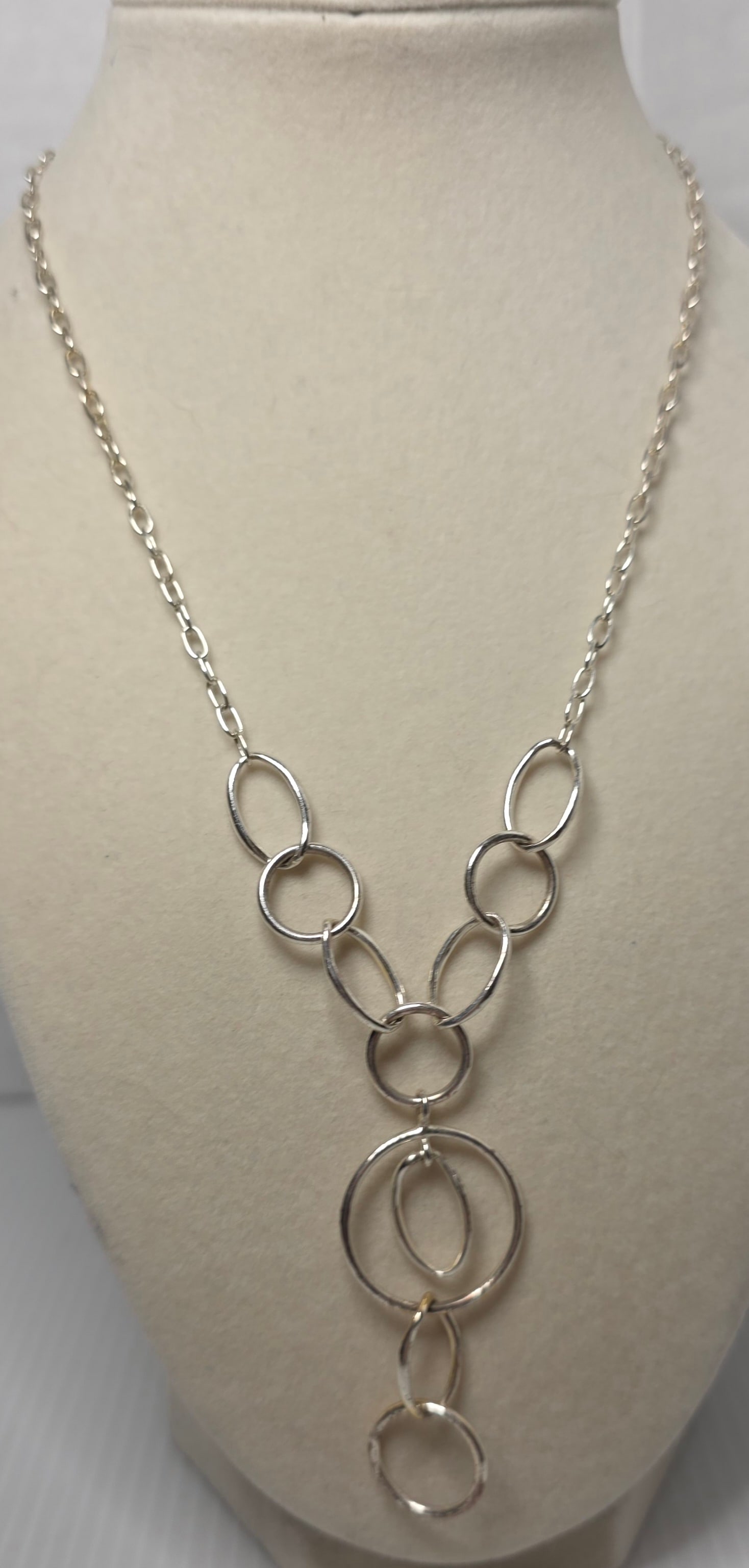 Silver Tone Open Circle Drop Necklace Unmarked: Silver tone necklace featuring graduated open circle links forming a drop style pendant design. Suspended from a matching link chain with lobster clasp closure.Unmarked metal.Measures approximately 20