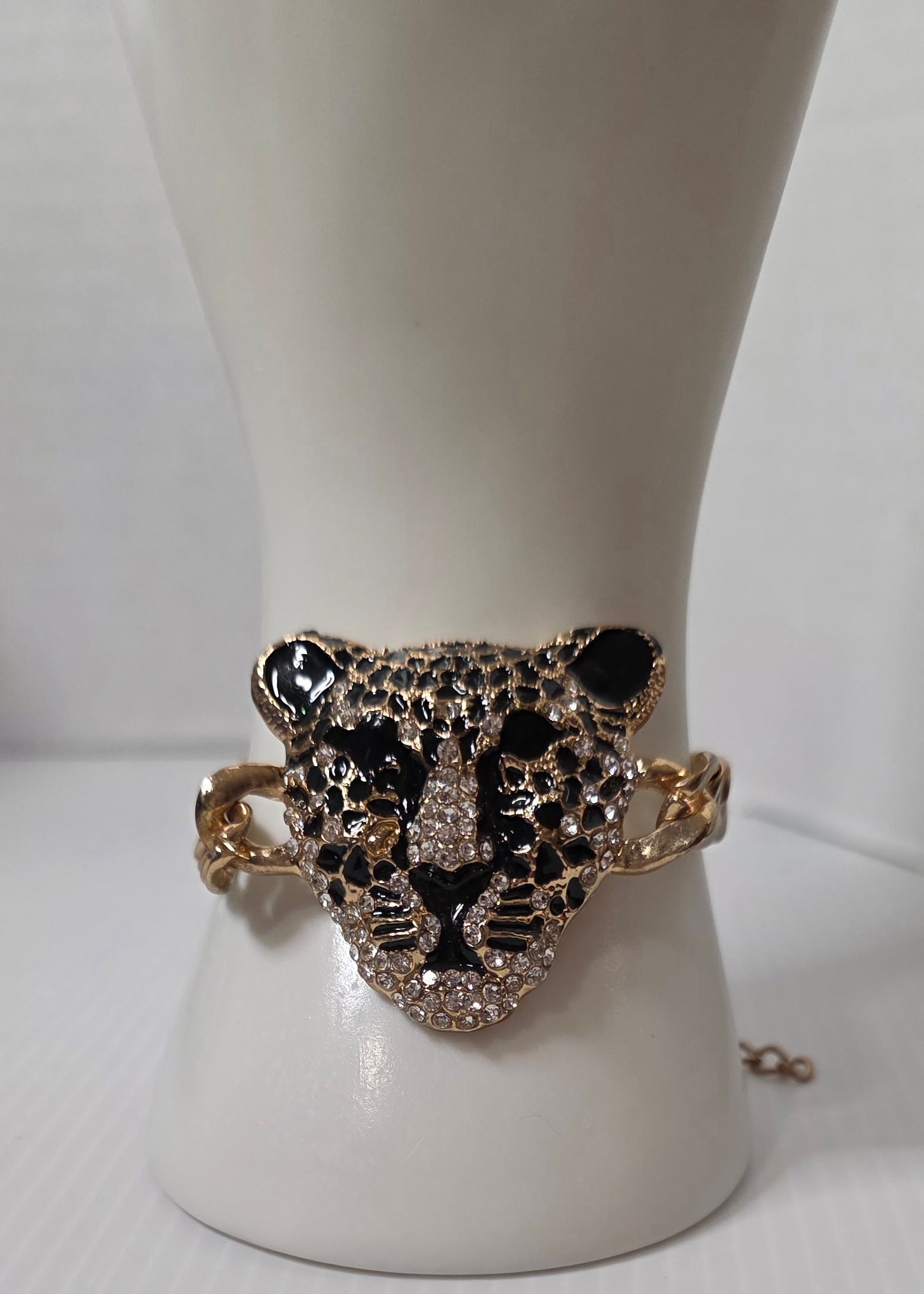 Gold Tone Leopard Head Bracelet Black Enamel Rhinestone: Gold tone chain bracelet featuring large leopard head centerpiece with black enamel detailing and clear rhinestone accents. Chunky curb style links with lobster clasp and extender chain.Measures appro