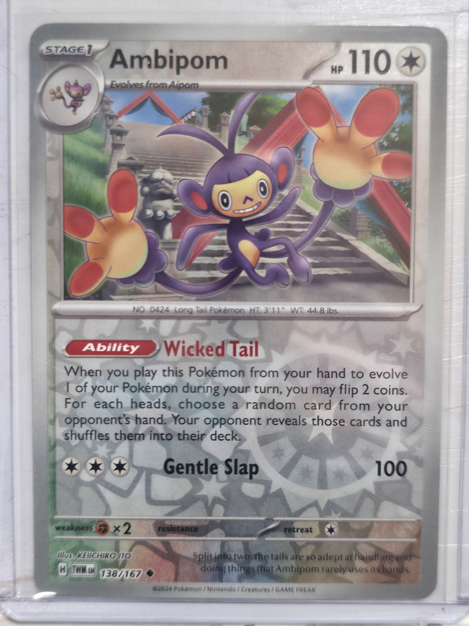 2024 Ambipom Twilight Masquerade 138/167 Reverse Holo: Background shows reflective foil pattern outside artwork frame confirming Reverse Holo version.Description:Ambipom Stage 1 Colorless Pokemon, evolves from Aipom. Twilight Masquerade set. Card number 1