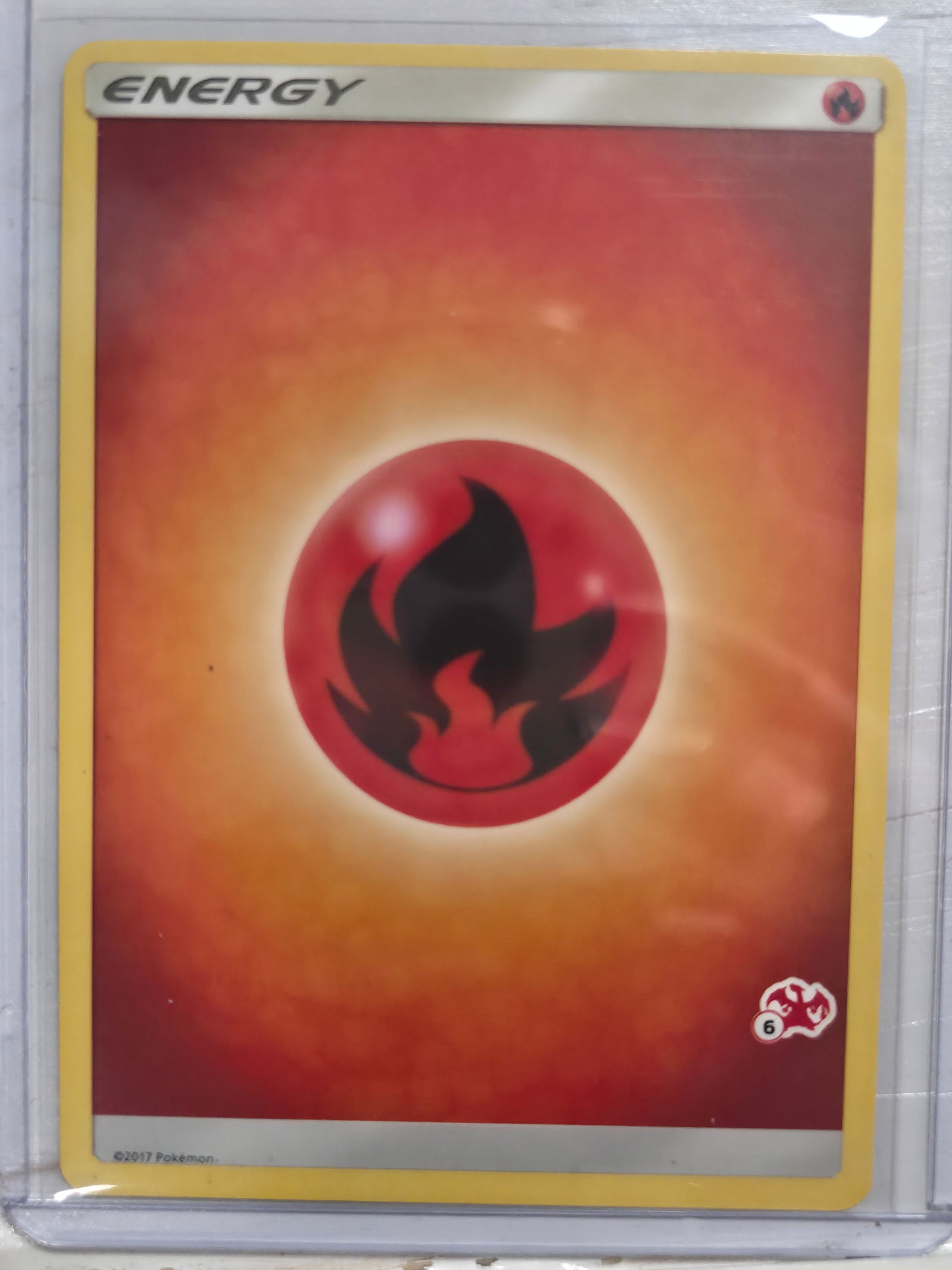 2017 Fire Energy Sun and Moon Promo 12/12 Common: Basic Fire Energy card. 2017 Sun and Moon era print. 12/12 variant with set stamp symbol at lower right. Standard non holo finish. 2017 Pokemon. Preowned card stored in penny sleeve and top loader.