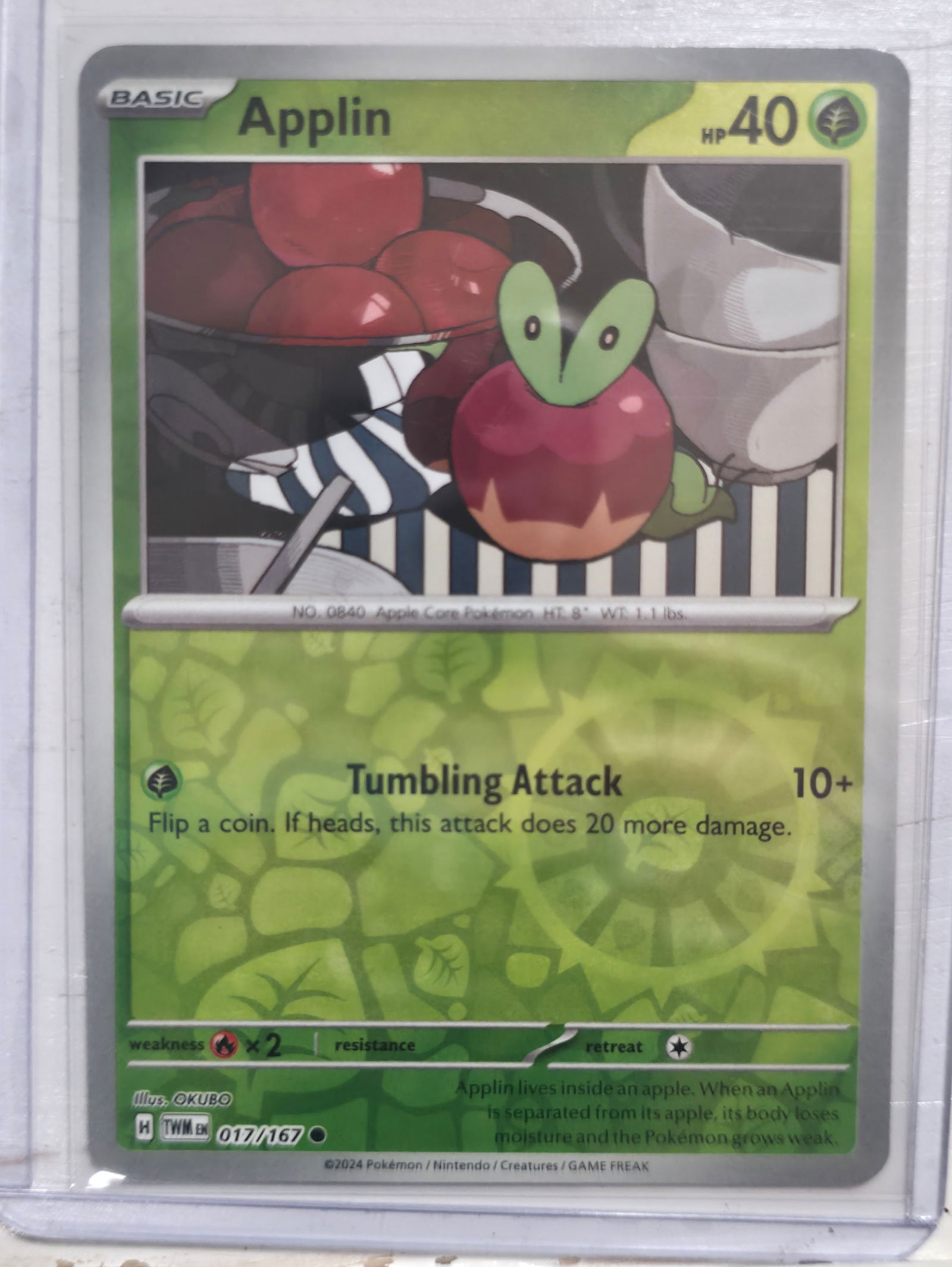 2024 Applin Twilight Masquerade 017/167 Common: 2024 Applin Basic Grass Pokemon. Twilight Masquerade set. Card number 017/167. Common non holo. HP 40. Attack Tumbling Attack. Illustrated by OKUBO. Regulation mark H. Preowned card stored in penny sl