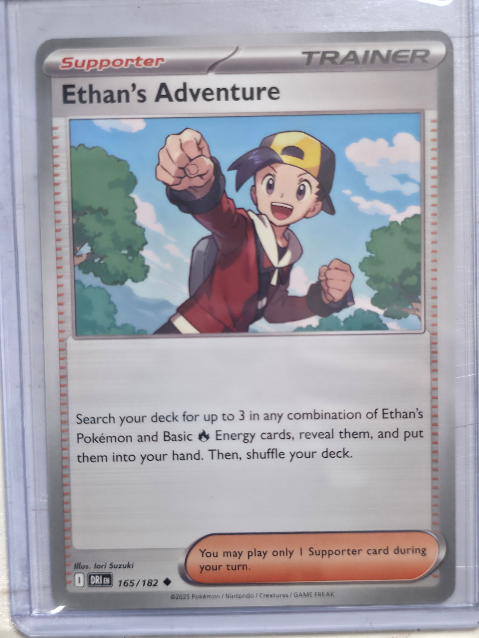 2025 Ethan's Adventure 165/182 Non Holo: 2025 Ethan's Adventure Supporter Trainer card. Card number 165/182. Non holo. Search your deck for up to 3 in any combination of Ethan's Pokemon and Basic Fire Energy cards. Illustrated by Iori Suzuki