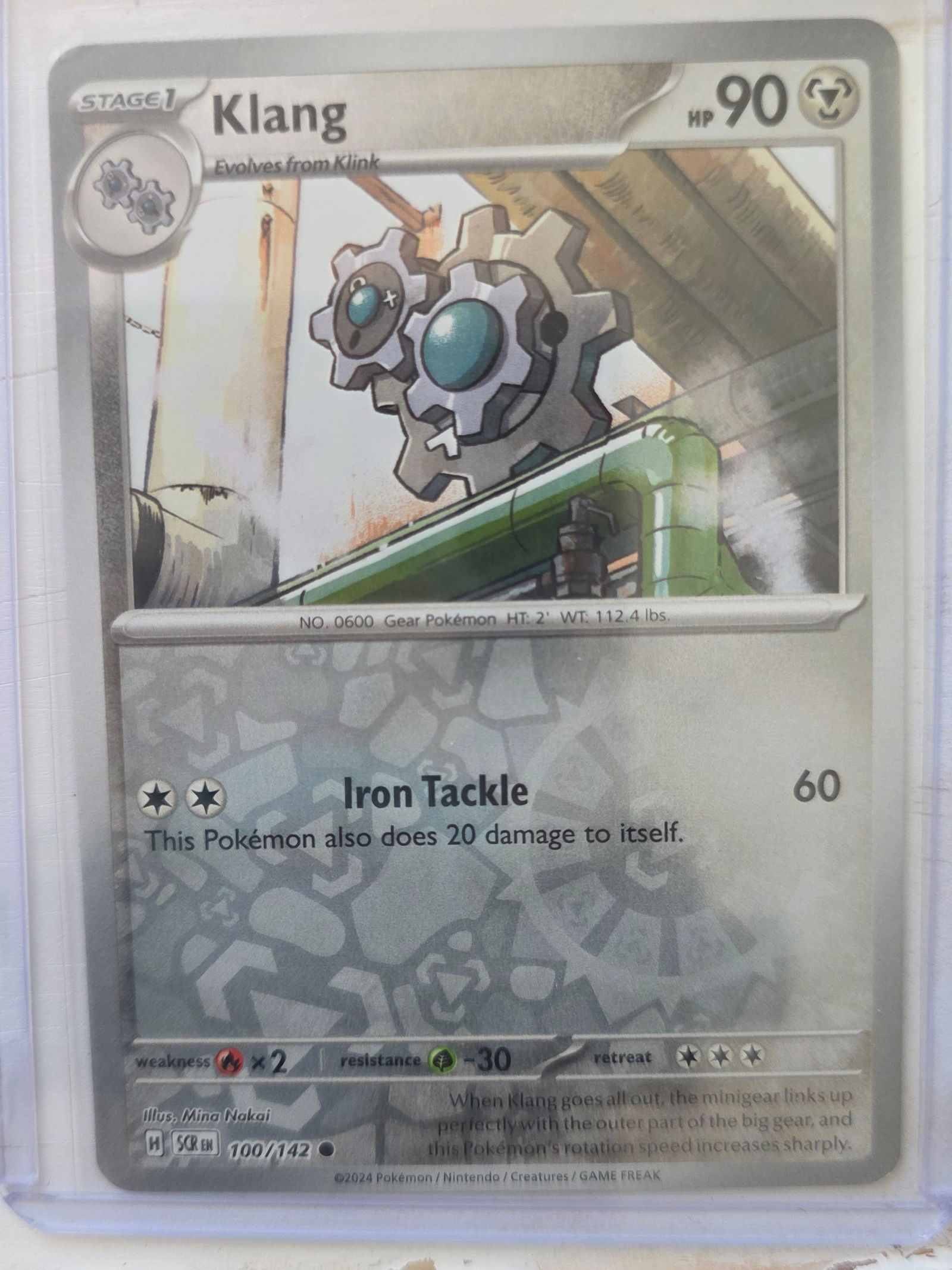 2024 Klang SCR 100/142 Reverse Holo: 2024 Klang Stage 1 evolves from Klink. SCR set. Card number 100/142. HP 90. Attack Iron Tackle 60. Reverse holo pattern visible on card front. Preowned card stored in penny sleeve and top loader. Sold