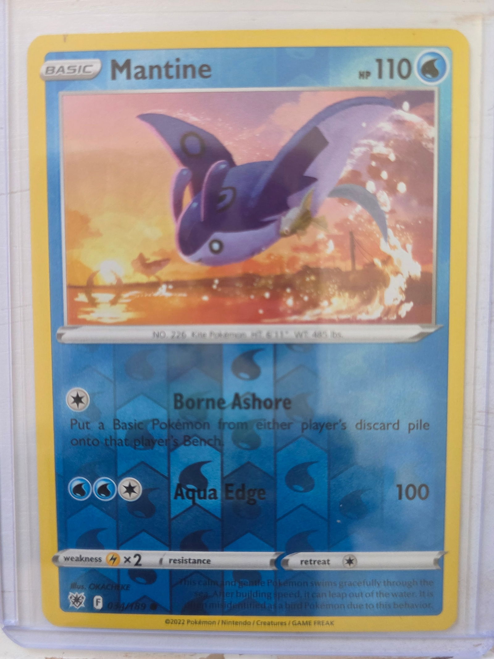 2022 Mantine 034/189 Reverse Holo: 2022 Mantine Basic card 034/189. 110 HP Water type. Reverse holo foil pattern across card surface with non holo artwork box. Borne Ashore ability. Aqua Edge 100. Preowned card stored in penny sleeve a