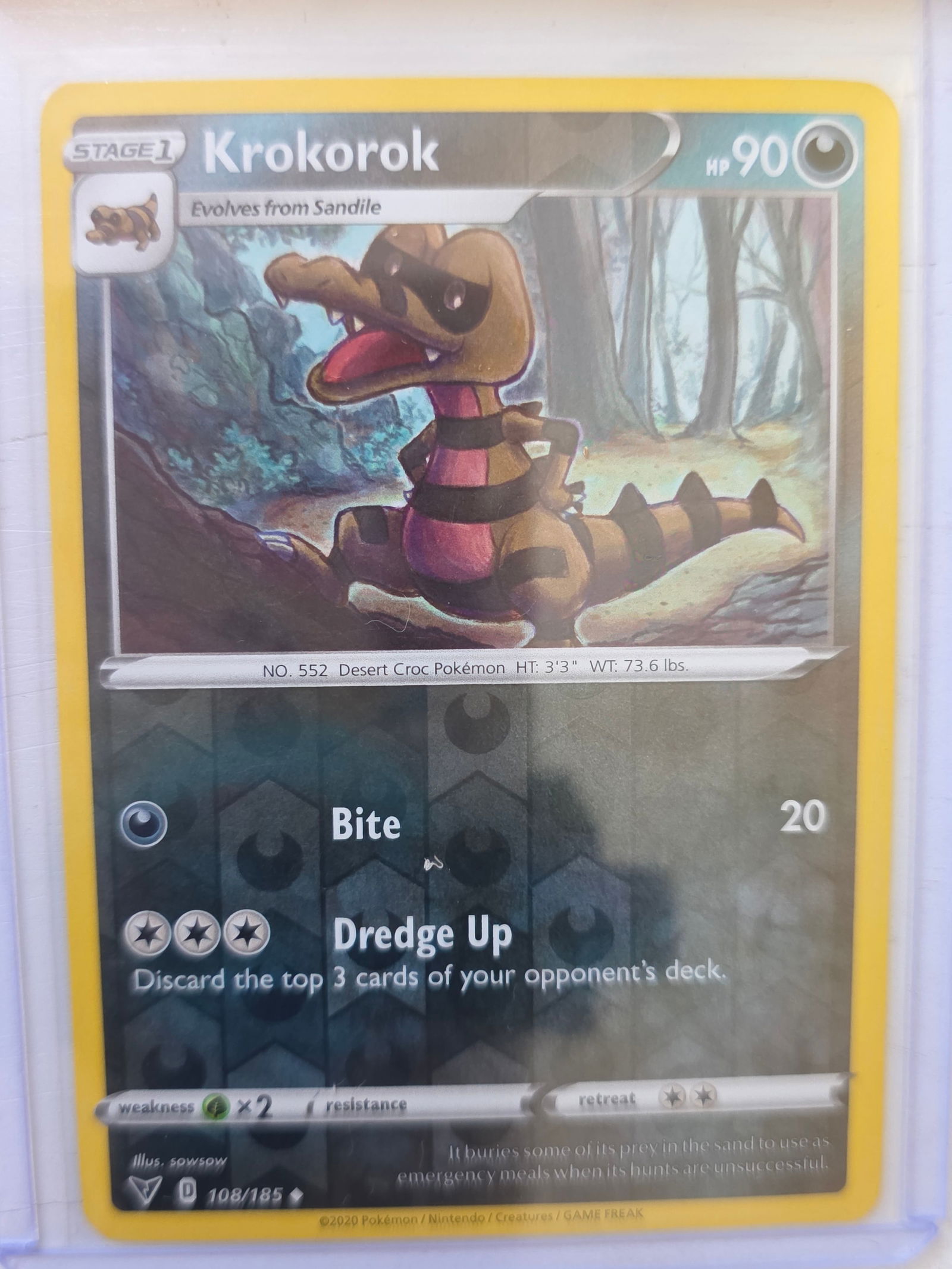 2020 Krokorok Vivid Voltage 108/185 Reverse Holo Pokemon Card: 2020 Pokemon Krokorok reverse holo card numbered 108/185 from the Sword & Shield Vivid Voltage expansion set. Illustrated by sowsow. Reverse holographic foil pattern across the card surface. Card stor