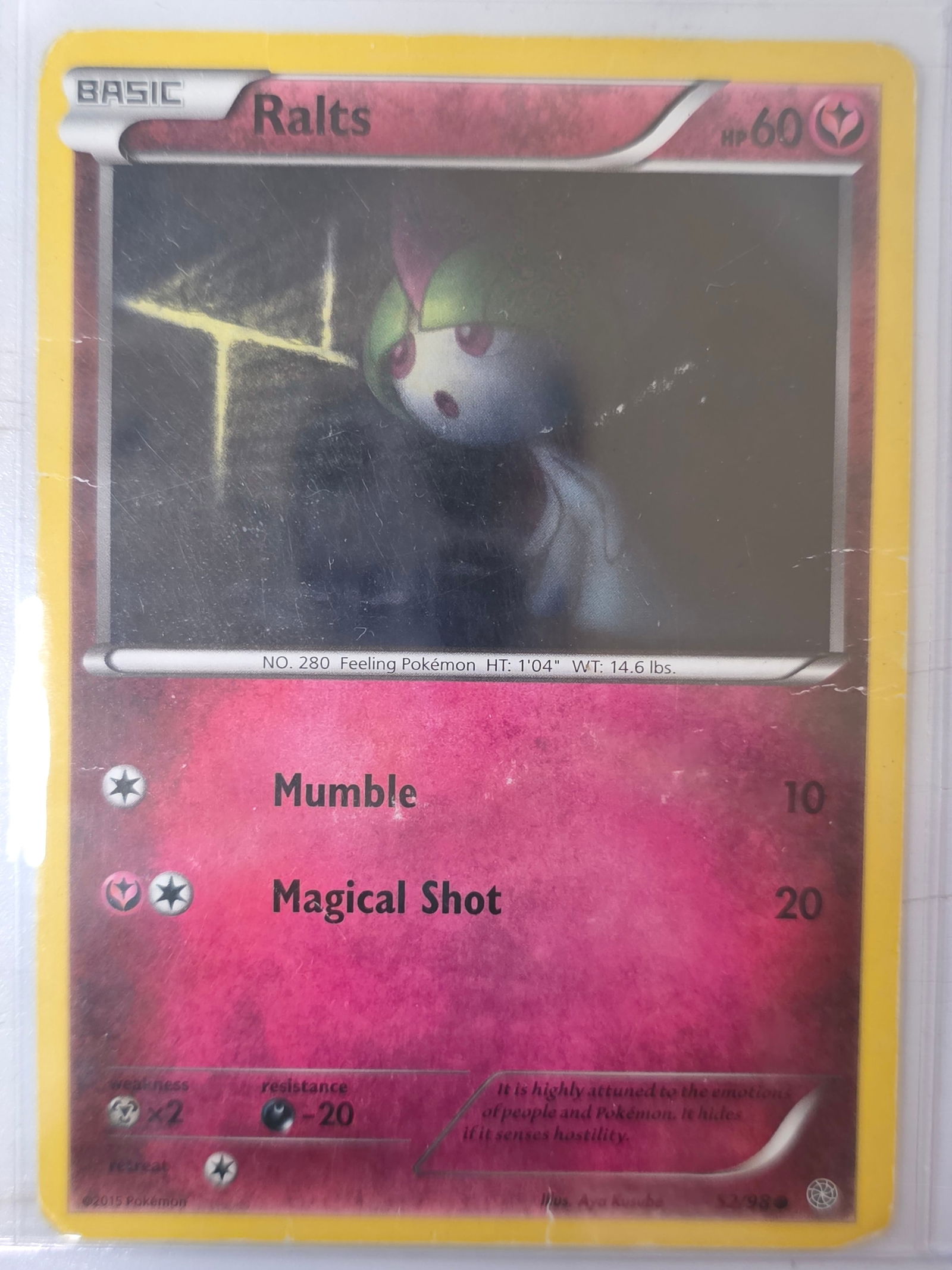 2015 Ralts Primal Clash 52/98 Pokemon Card: 2015 Pokemon Ralts basic card numbered 52/98 from the XY Primal Clash expansion set. Illustrated by Aya Kusube. Card stored in penny sleeve and top loader.