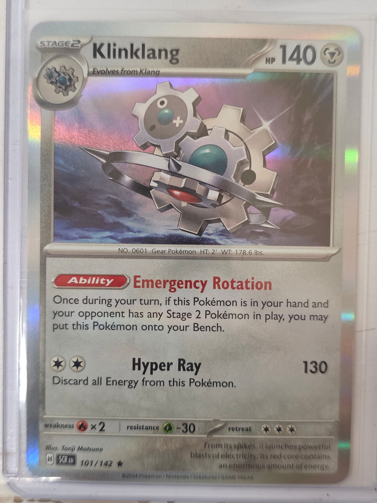 2024 Klinklang Stellar Crown 101/142 Holo Pokemon Card: 2024 Pokemon Klinklang Stage 2 holographic card numbered 101/142 from the Scarlet & Violet Stellar Crown expansion set. Illustrated by Tonji Matsuno. Holographic foil pattern across the illustration w