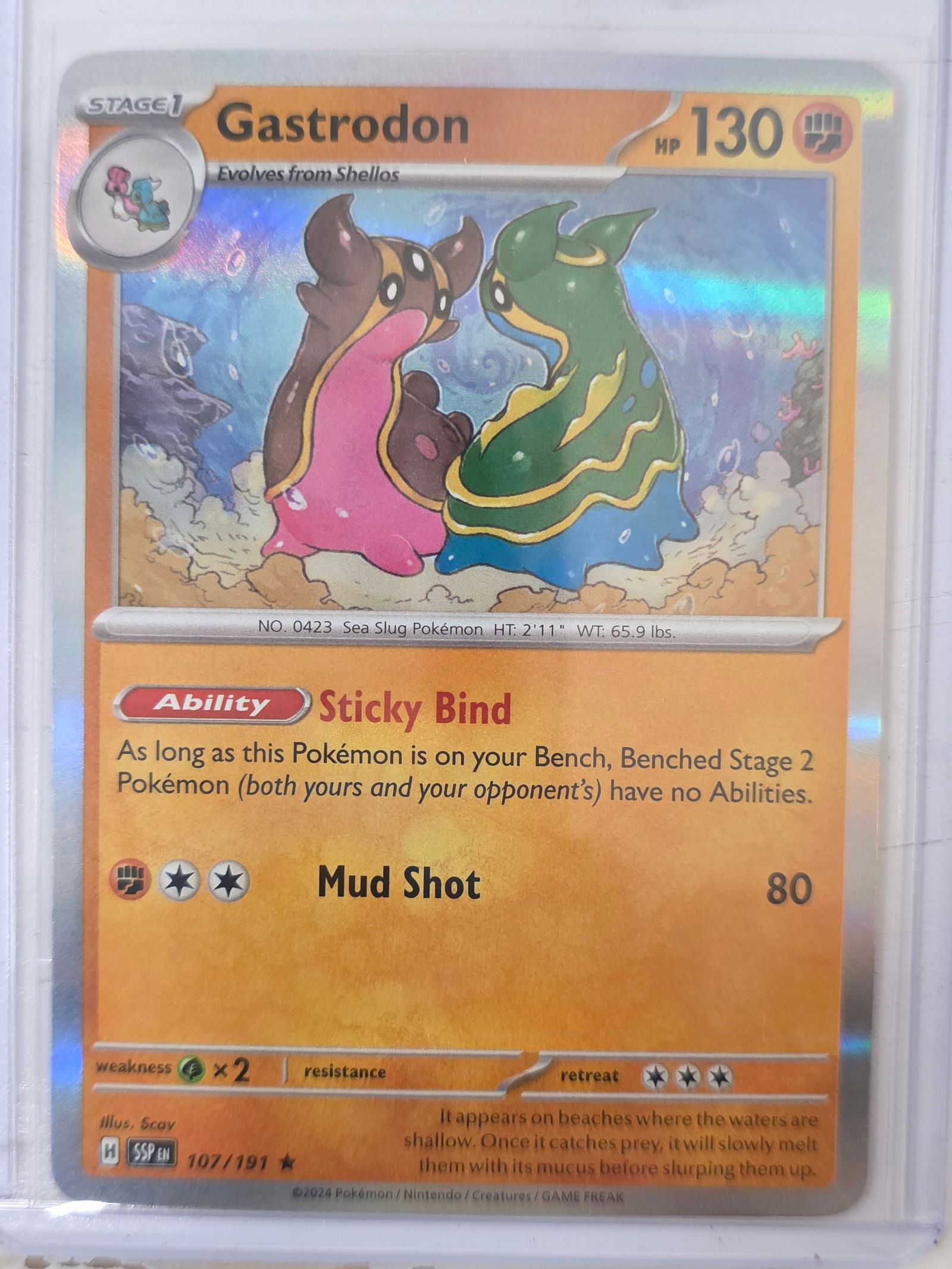 2024 Gastrodon Surging Sparks 107/191 Reverse Holo Pokemon Card: 2024 Pokemon Gastrodon reverse holo card numbered 107/191 from the Scarlet & Violet Surging Sparks expansion set. Illustrated by Scav. Reverse holographic foil pattern across the card surface. Card st