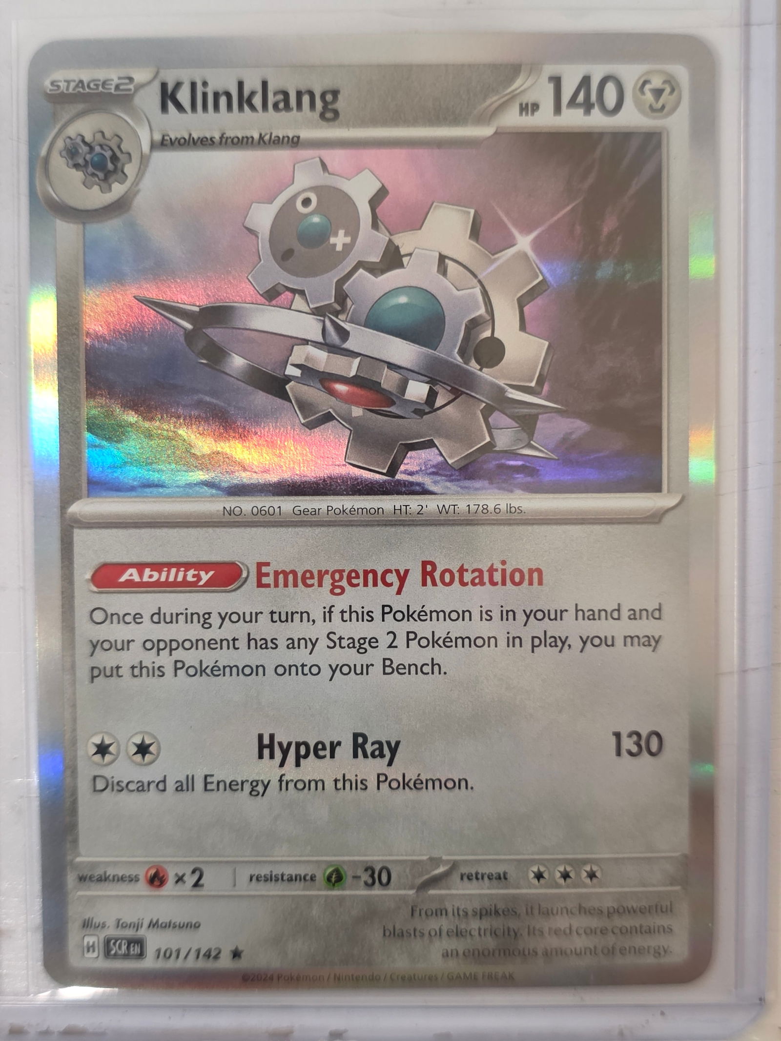 2024 Klinklang Stellar Crown 101/142 Holo Rare Pokemon Card: 2024 Pokemon Klinklang holographic rare card numbered 101/142 from the Scarlet & Violet Stellar Crown expansion set. Illustrated by Tonji Matsuno. Standard holographic rare finish. Card stored in penn