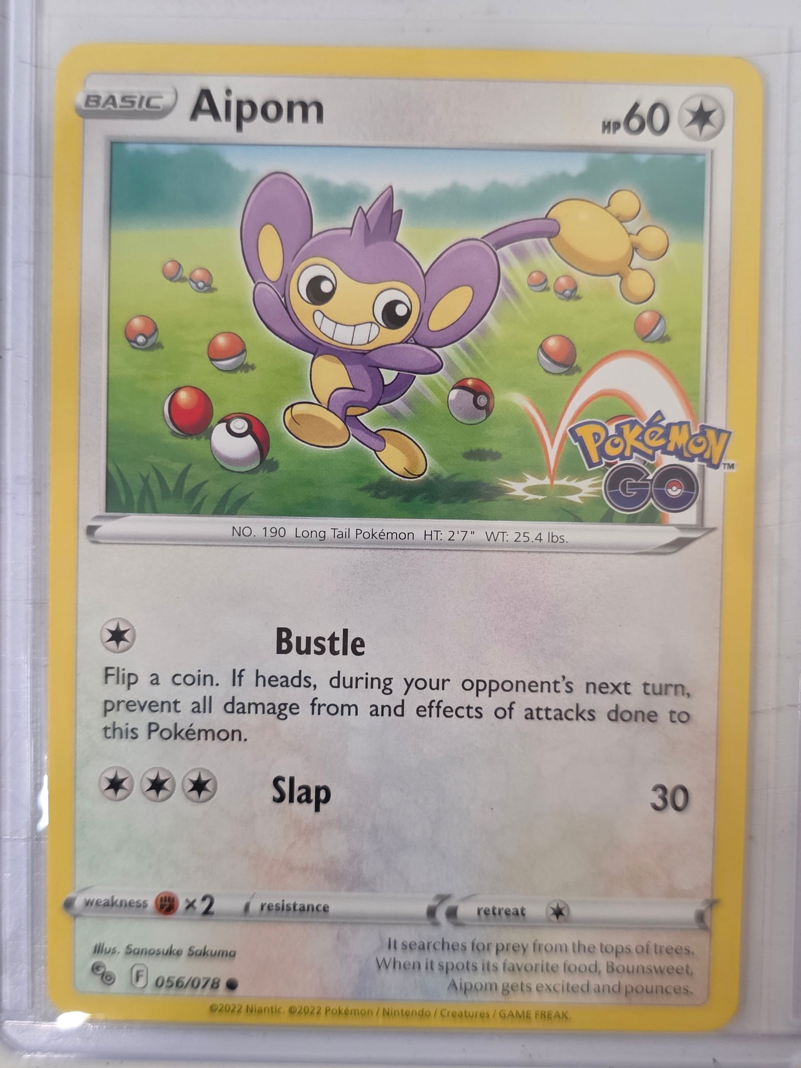 2022 Aipom Pokemon GO 056/078 Pokemon Card: 2022 Pokemon Aipom card numbered 056/078 from the Pokemon GO expansion set. Illustrated by Sanosuke Sakuma. Standard non-holographic card. Card stored in penny sleeve and top loader.