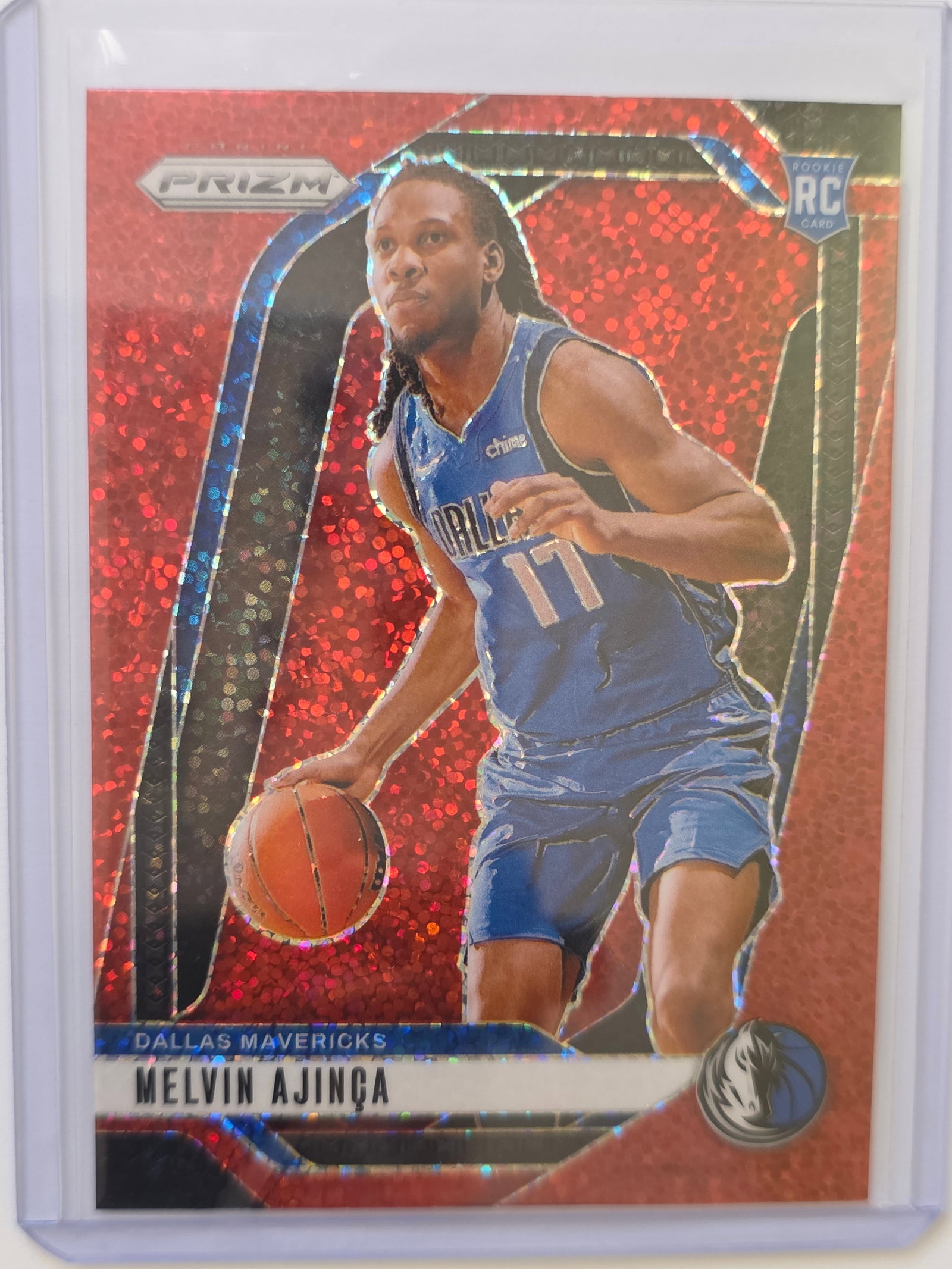 Melvin Ajinca ROOKIE RED PRIZM 2024 Panini Prizm Dallas Mavericks #255: 2024 Panini Prizm Melvin Ajinca Rookie Red Prizm #255 for the Dallas Mavericks. Red prizm parallel with strong color and reflective finish. Stored in protective sleeve and holder. See photos for cente