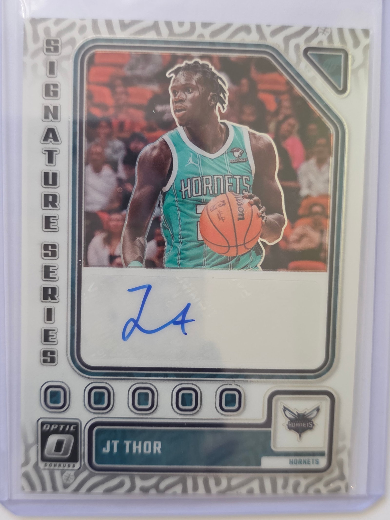 JT Thor AUTO Signature Series 2023 Panini Donruss Optic Hornets: 2023-24 Panini Donruss Optic JT Thor Signature Series Autograph for the Charlotte Hornets. Features certified autograph with Optic chrome-style finish. Clean modern insert from the Optic line. Stored