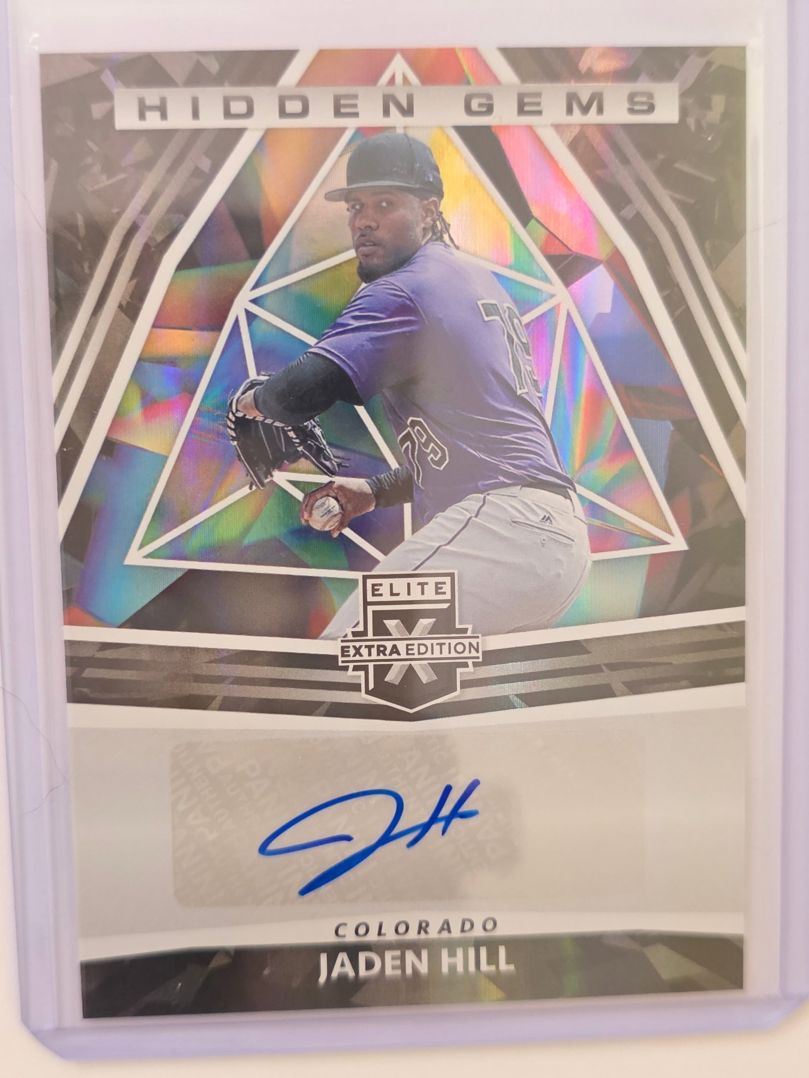 Jaden Hill Hidden Gems Auto 2022 Panini Elite Extra Edition: 2022 Panini Elite Extra Edition Jaden Hill Hidden Gems autograph card featuring Colorado prospect. Eye-catching holographic Hidden Gems insert with blue ink autograph. Autograph is guaranteed by Panin