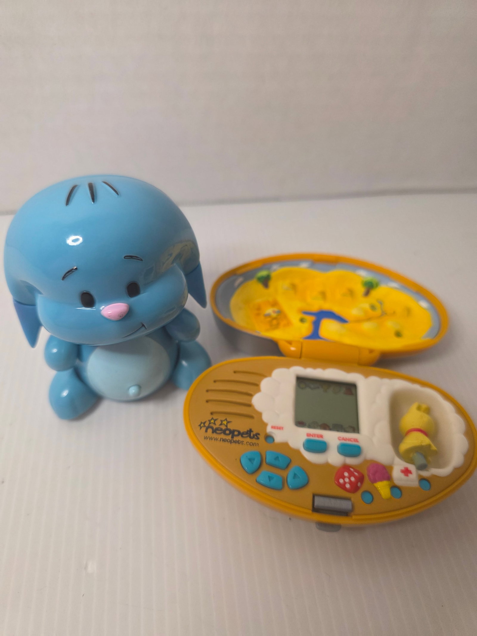 Neopets Virtual Pet Toy Lot Aisha Handheld Game Plushie Kougra Electronic: Lot of Neopets electronic virtual pet toys from the early 2000s. This lot includes a Neopets handheld virtual pet game featuring the character Aisha. The device is marked with the Neopets logo and neo