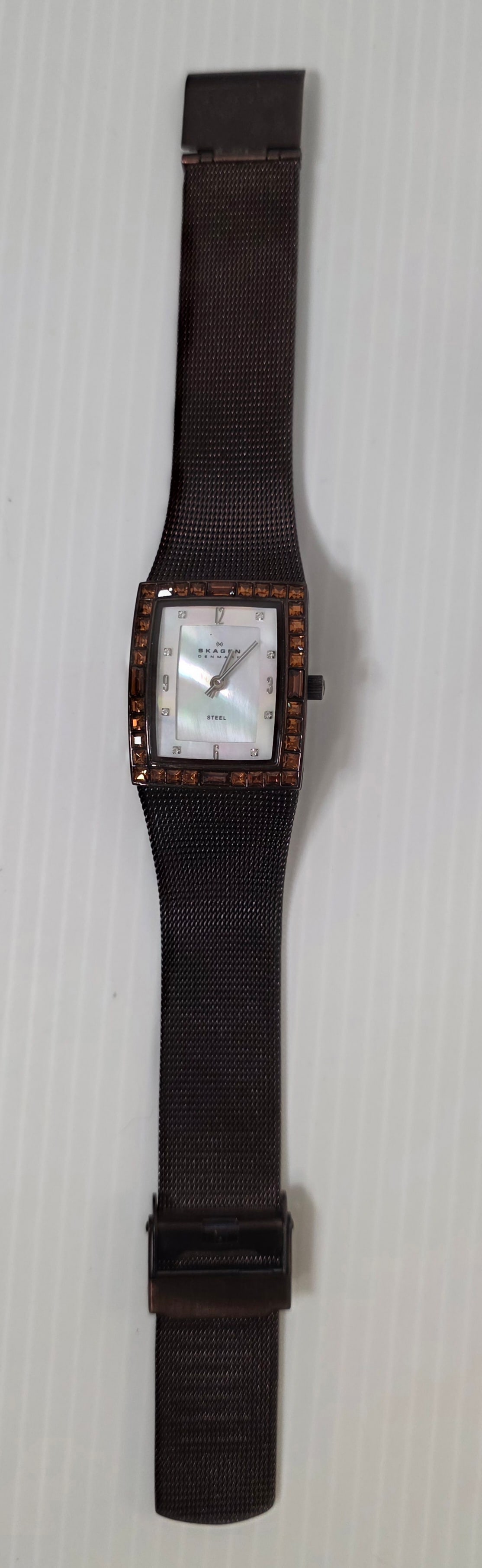 Skagen Denmark Steel Watch Brown Mesh Band Crystal Bezel Needs Battery: Skagen Denmark rectangular wristwatch with brown tone stainless steel mesh band and matching case. The bezel is set with square amber tone crystals.The watch features a mother of pearl style dial with