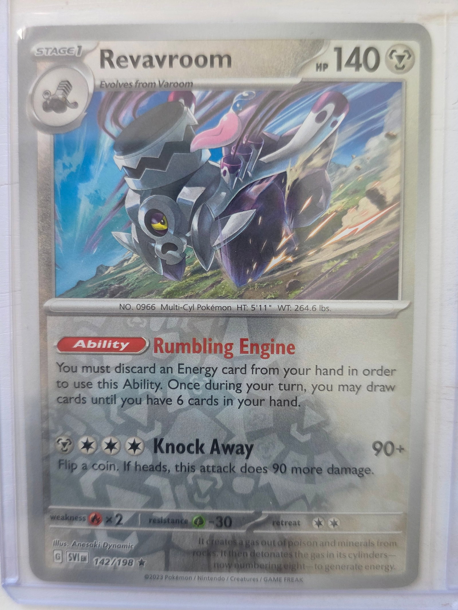2023 Revavroom 142/198 Holo Rare: 2023 Revavroom Stage 1 card 142/198 evolving from Varoom. 140 HP Metal type. Holo foil artwork with reflective background. Ability Rumbling Engine. Knock Away 90+. Preowned card stored in penny