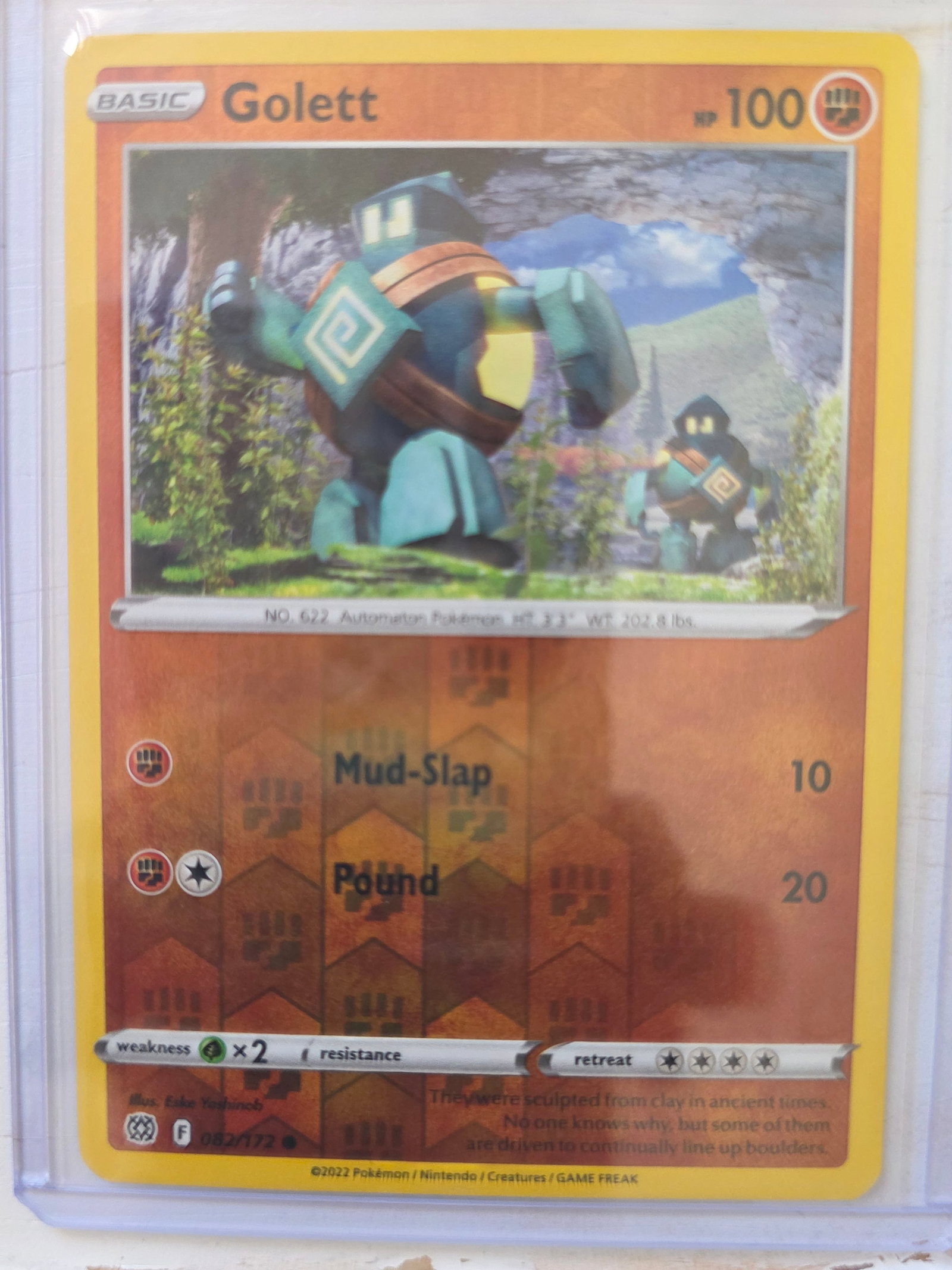 2022 Golett 082/172 Reverse Holo: 2022 Golett Basic card 082/172. 100 HP Fighting type. Reverse holo foil pattern across card surface with non holo artwork box. Mud-Slap 10. Pound 20. Preowned card stored in penny sleeve and top loade